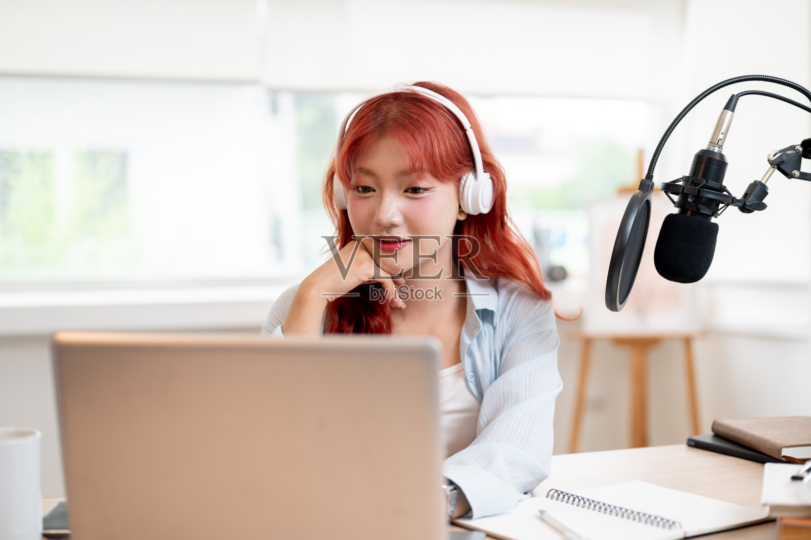 体贴的亚洲女播客主播一边直播，一边阅读在线频道上的评论。照片摄影图片