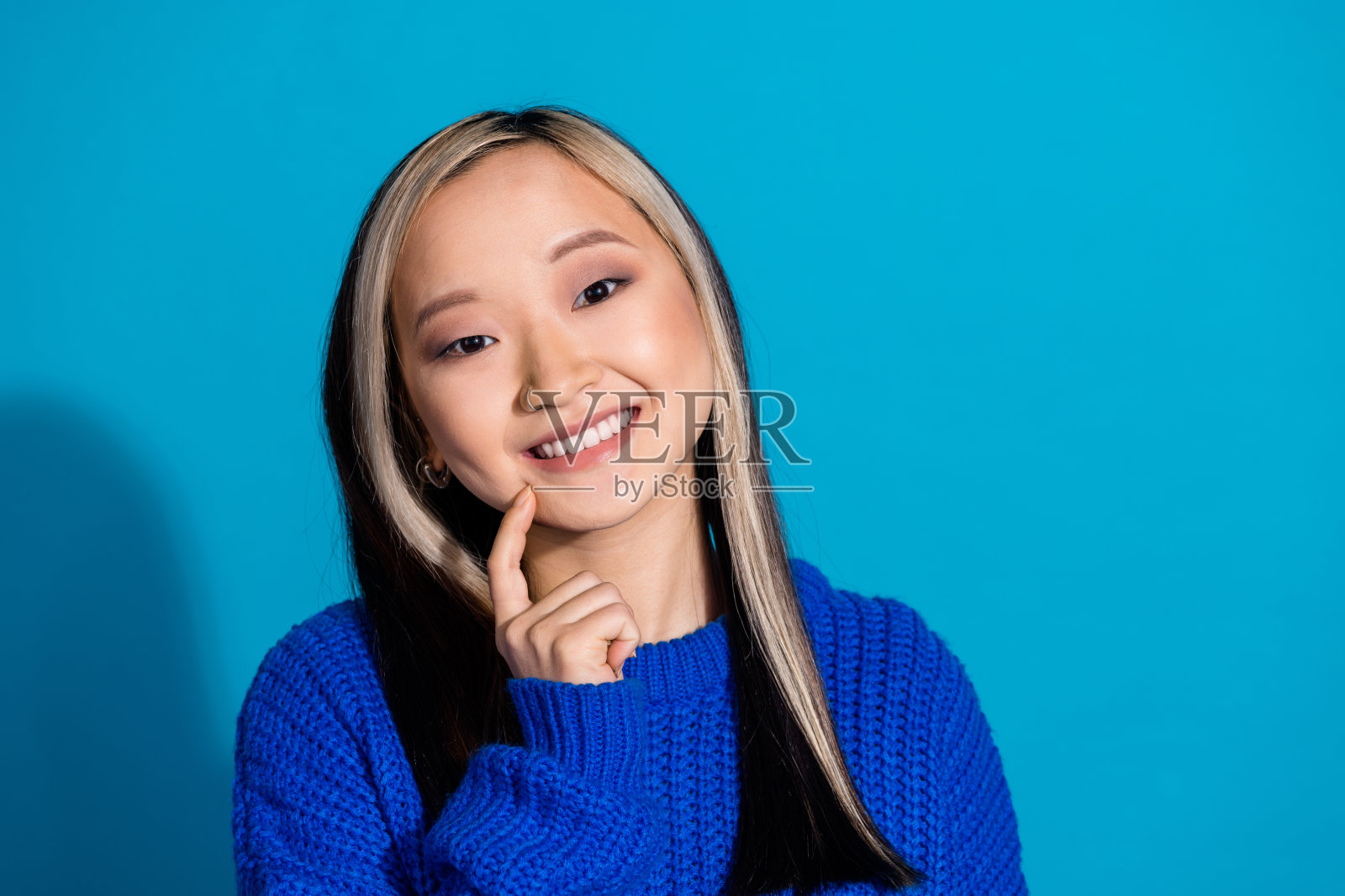 照片肖像迷人的年轻女子头脑触摸下巴穿着时尚的针织品衣服孤立的蓝色背景照片摄影图片