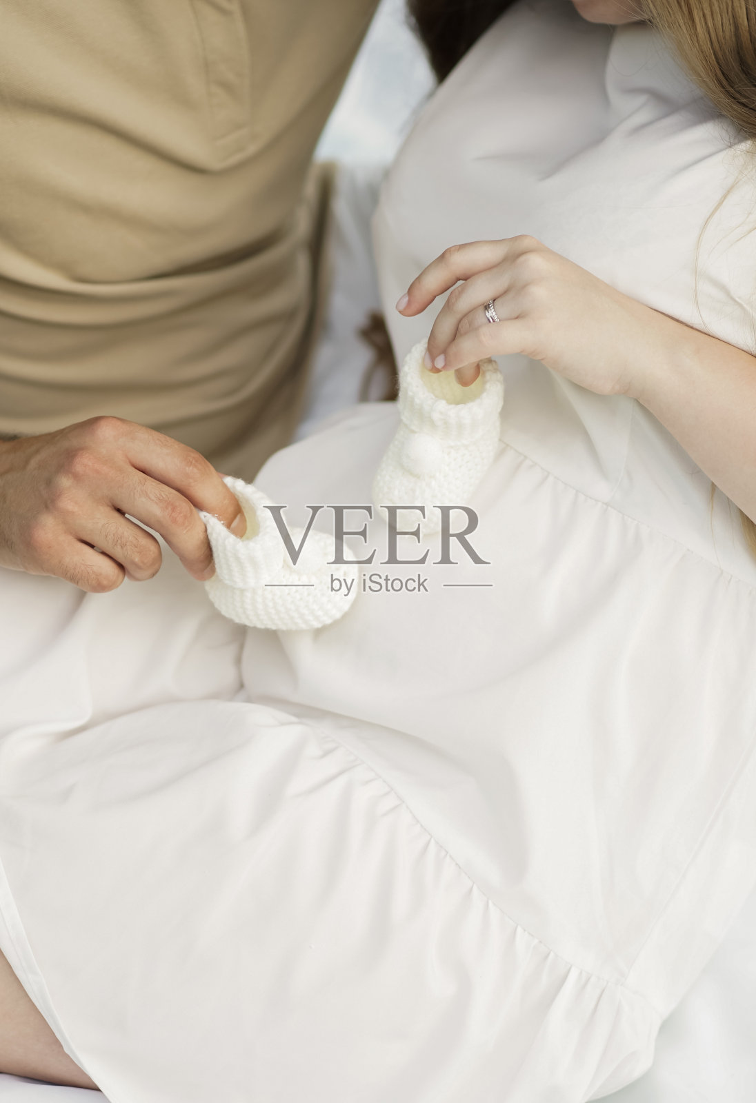 一个男人和一个女人拿着婴儿靴。为为人父母做准备的概念。照片摄影图片