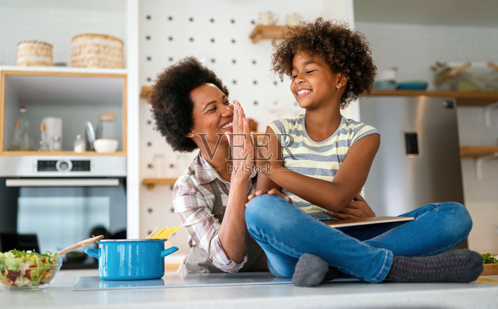 快乐的黑人妇女和她可爱的青春期前的女儿在家里一起玩的画像照片摄影图片