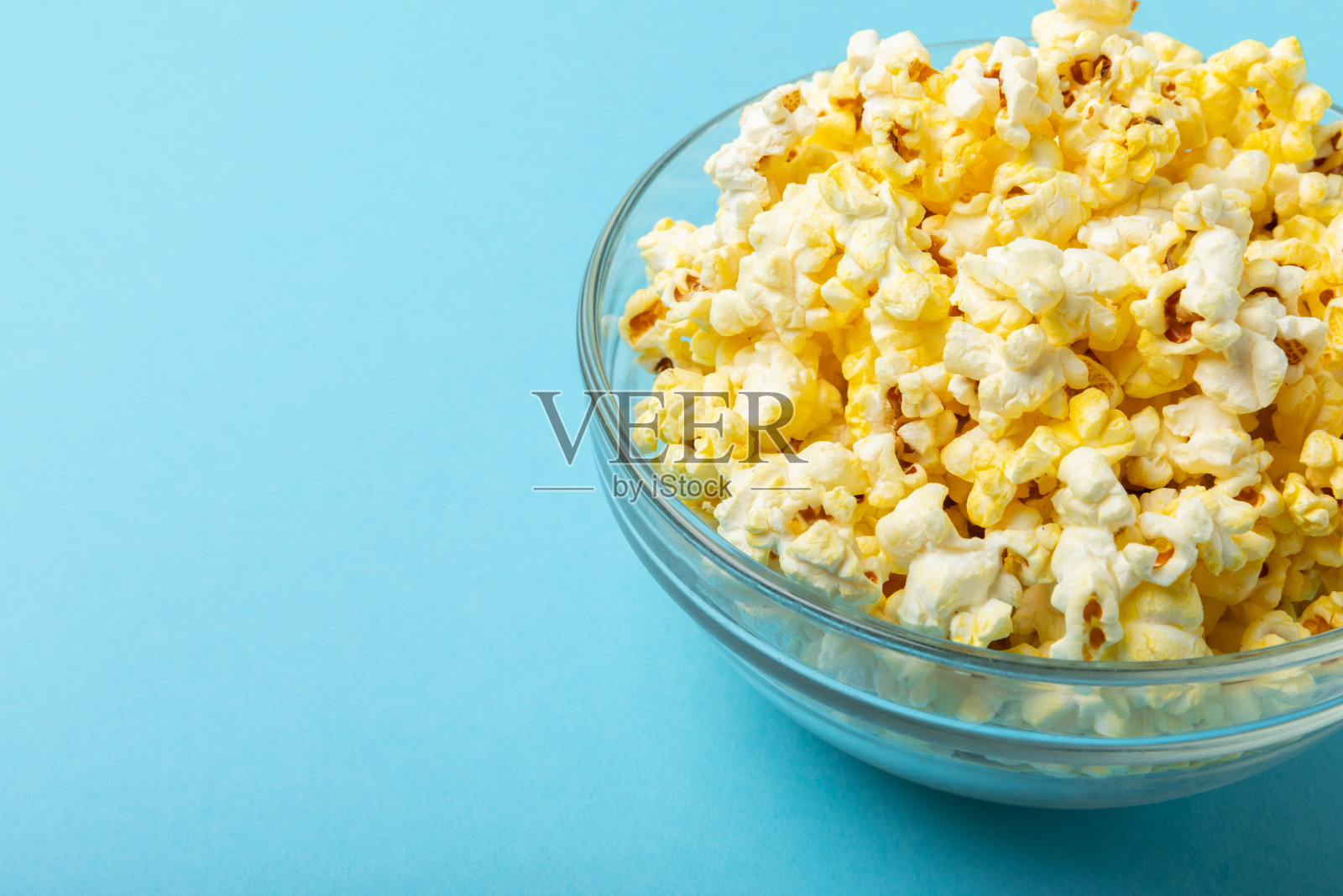 木制背景上美味的爆米花。电影院和娱乐的概念。有爆米花的电影之夜。奶酪和焦糖爆米花。美味的开胃菜，小吃。放文字的地方。副本的空间。横幅照片摄影图片