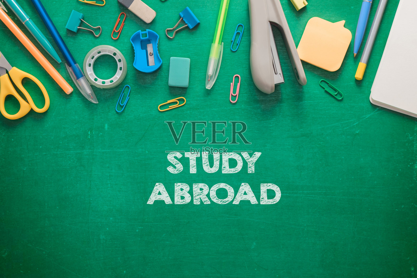 一块绿色的黑板和一堆办公用品照片摄影图片