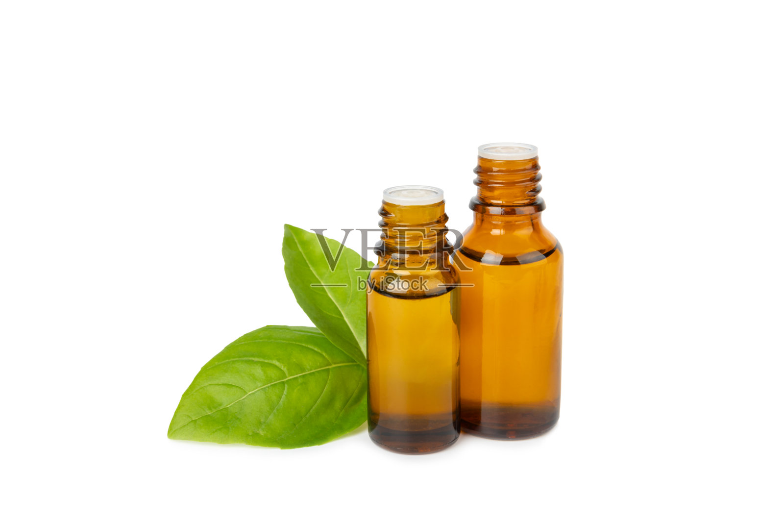 罗勒精油在纹理木制背景。罗勒精油和新鲜叶。芳香疗法。香味油。医学草药。替代医学。放文字的地方。副本的空间。照片摄影图片