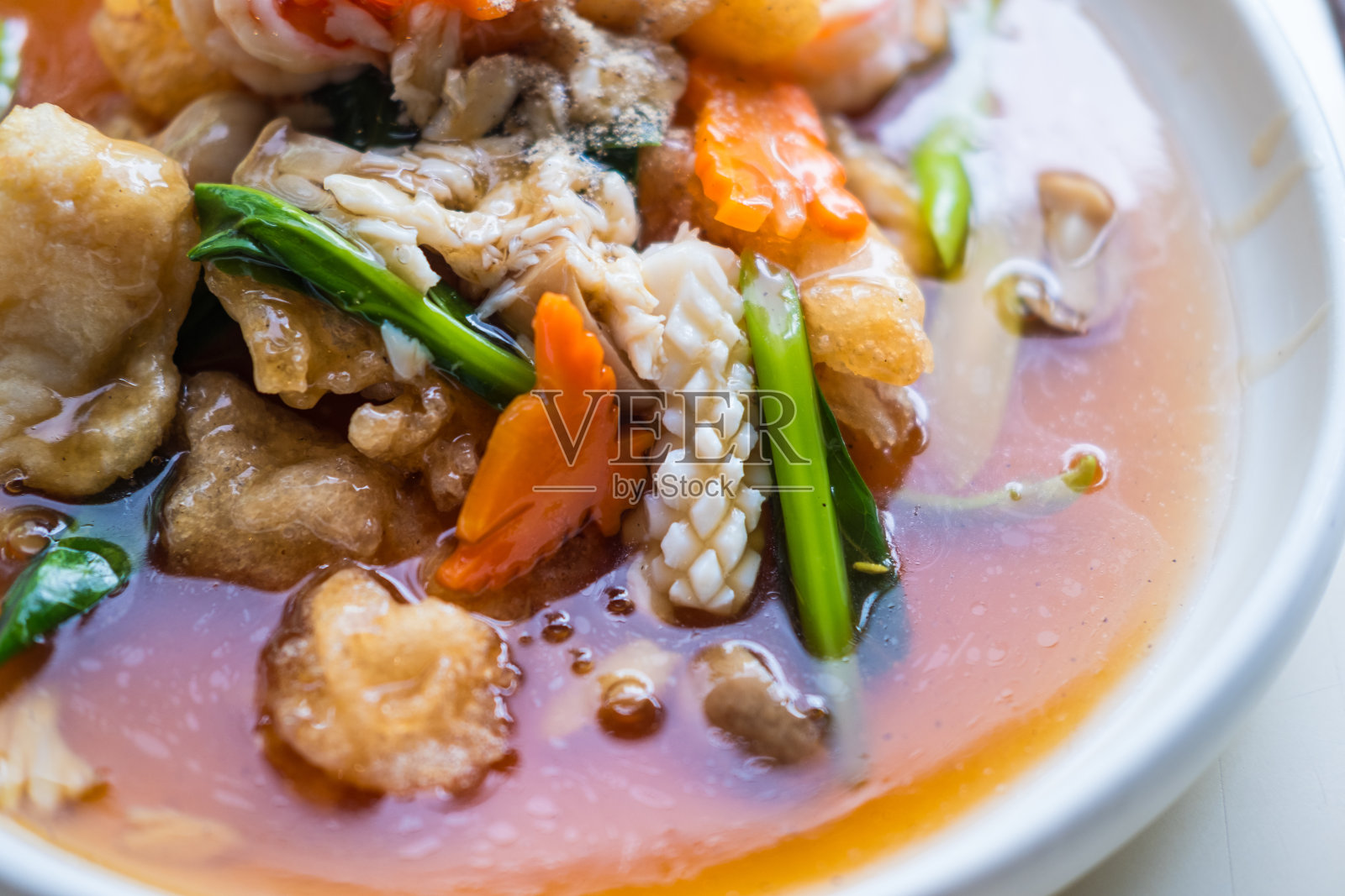 餐馆里白色盘子里的海鲜肉汁宽米粉。照片摄影图片