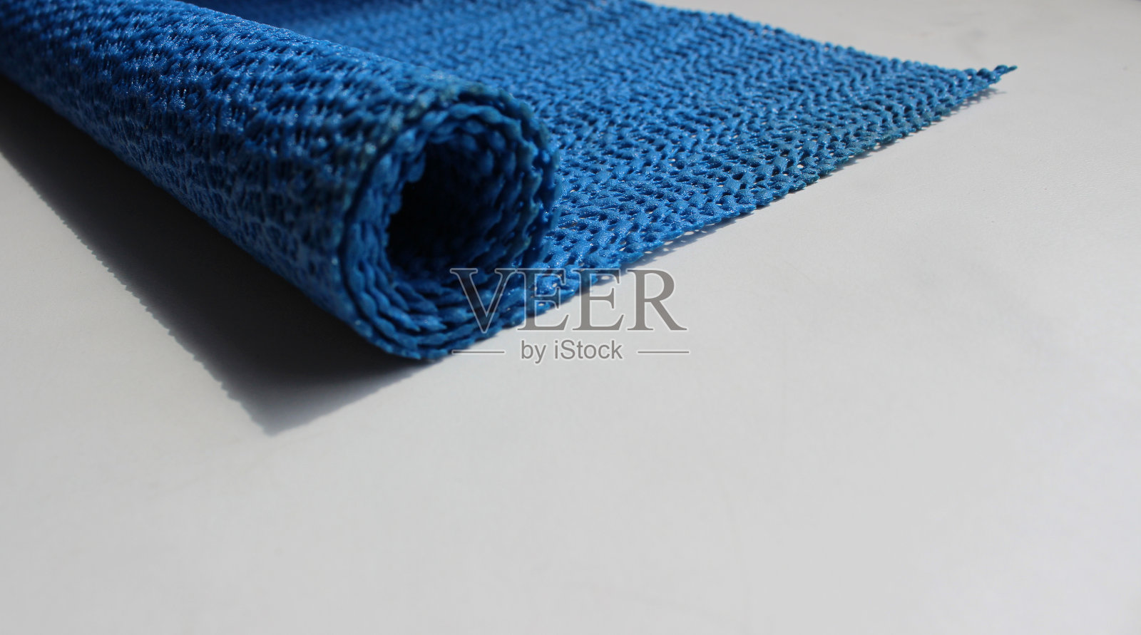 深蓝色防滑垫滚在干净的工作台表面照片摄影图片