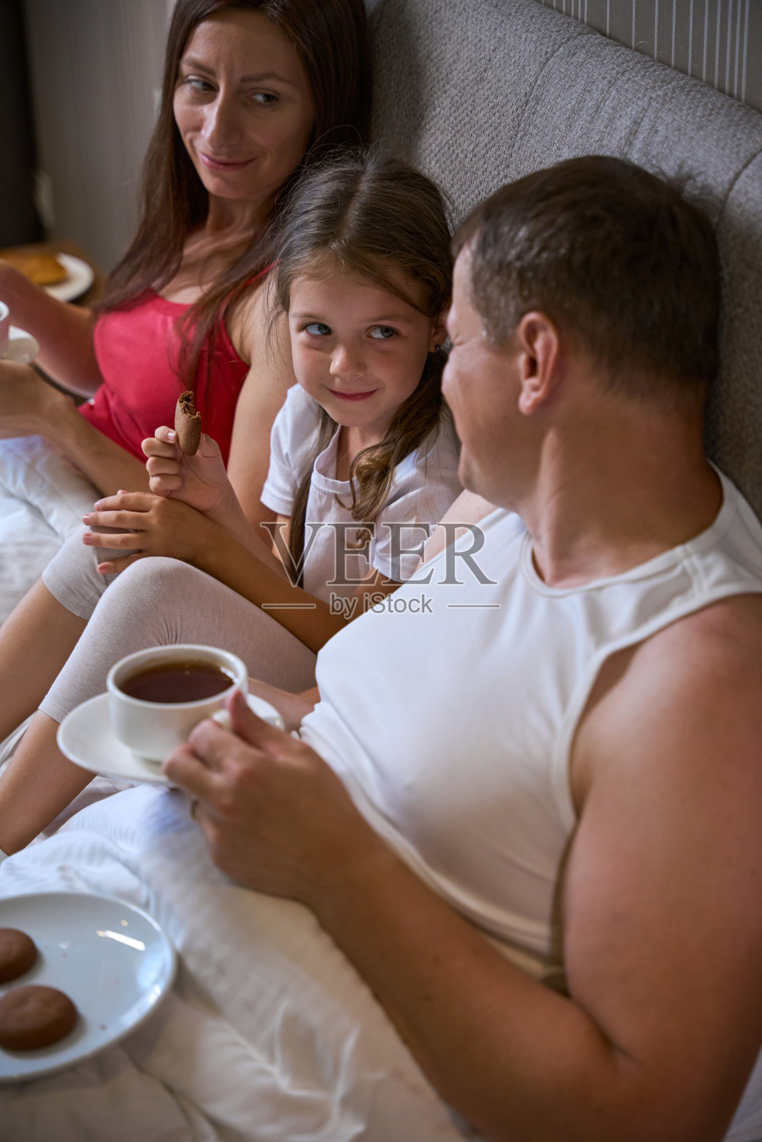 幸福的家庭在床上吃早餐照片摄影图片