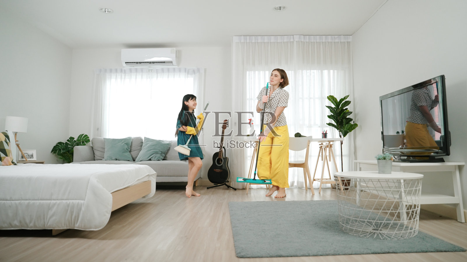 白人妈妈和孩子一起做家务，跟着音乐跳舞。教育学。照片摄影图片