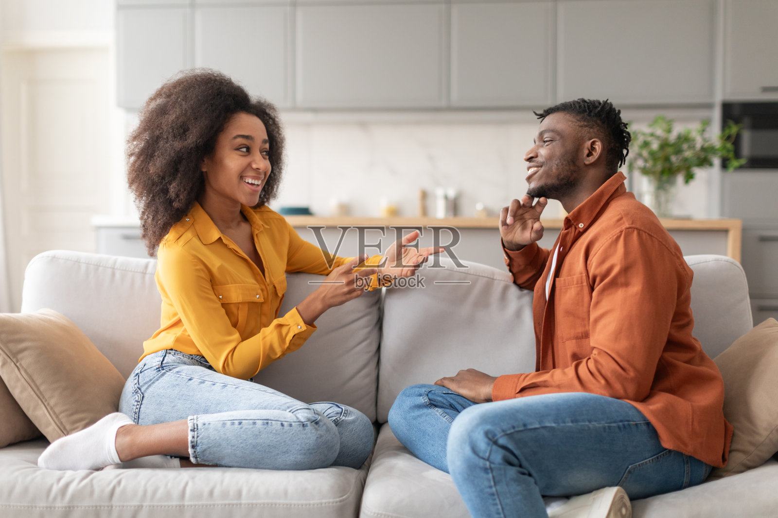 一对快乐的黑人夫妇坐在客厅的沙发上聊天照片摄影图片