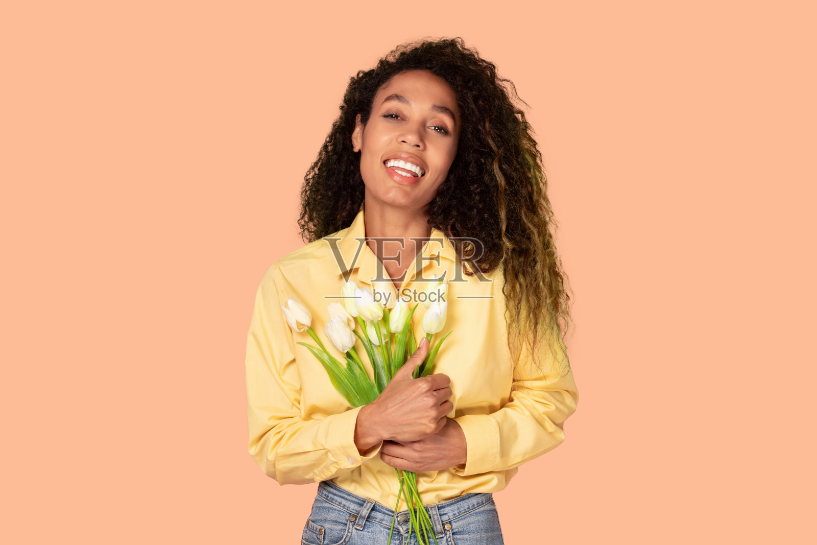 微笑的黑人妇女手持白色郁金香花束摆姿势照片摄影图片