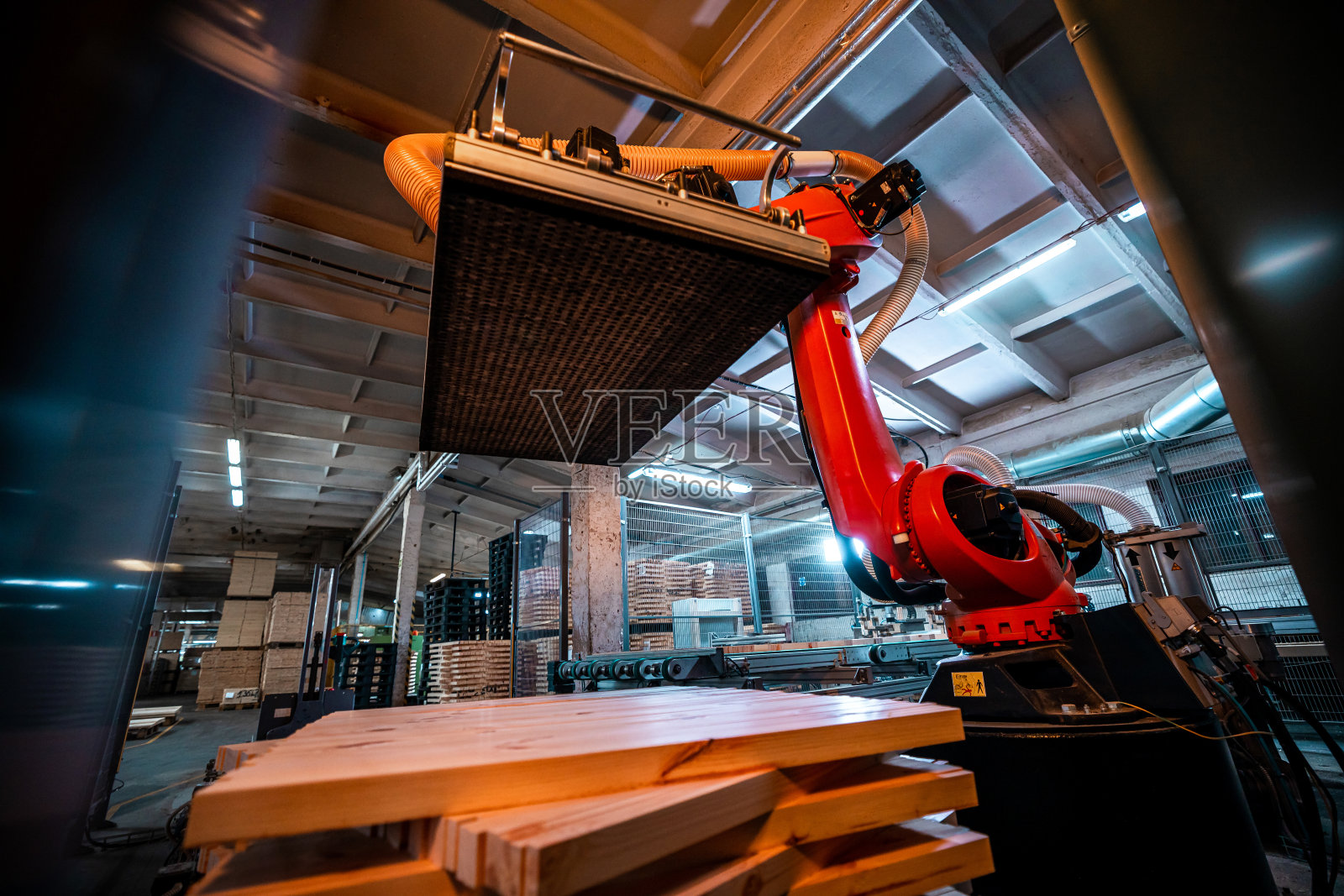 木工工厂的机械臂，配备了吸力技术，提升和加工木板，突出了现代制造业的自动化照片摄影图片