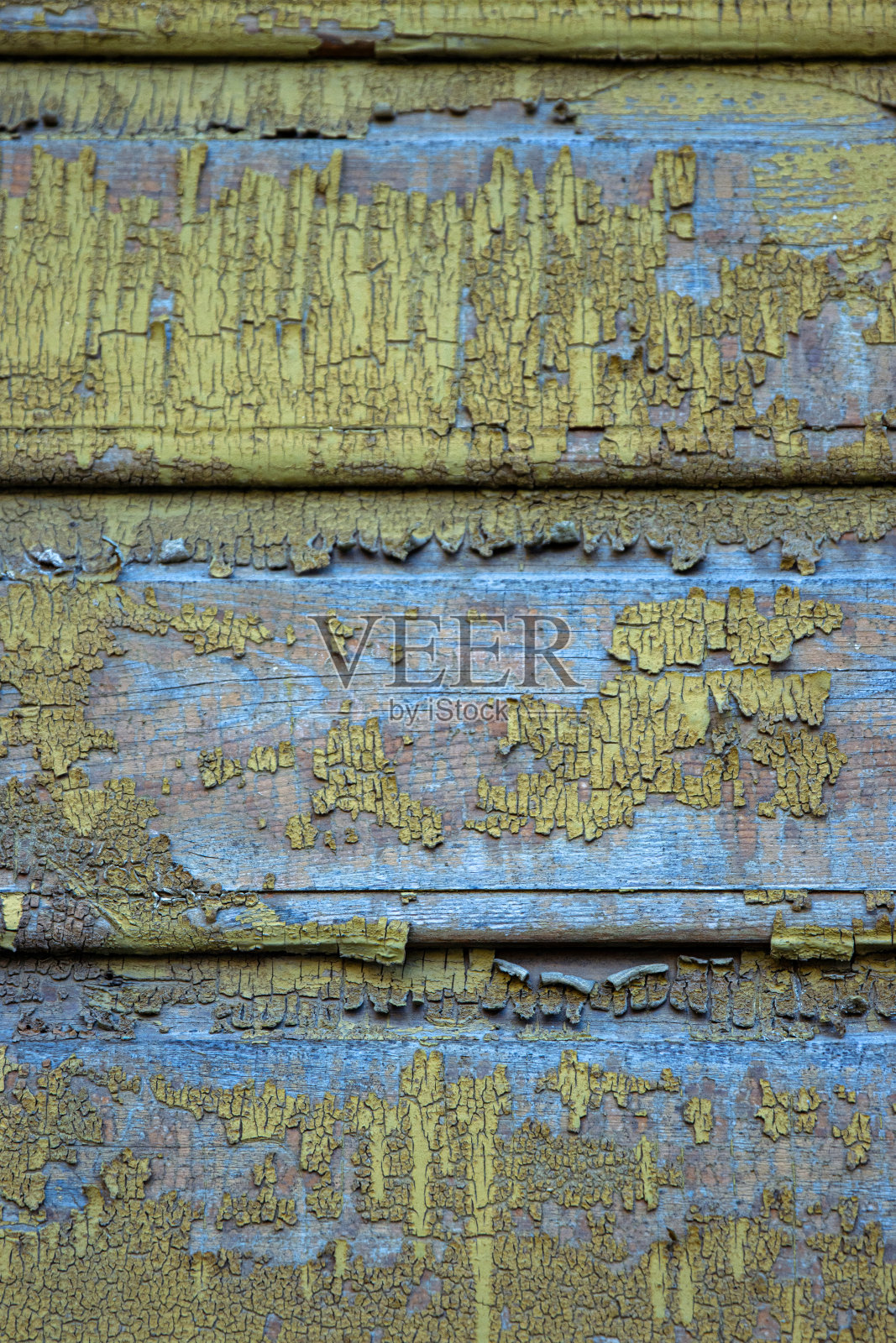 质朴的木材表面，剥落的黄色油漆和下面的蓝色层。非常适合用于创意背景或工业设计元素，grunge纹理和古董设计项目照片摄影图片