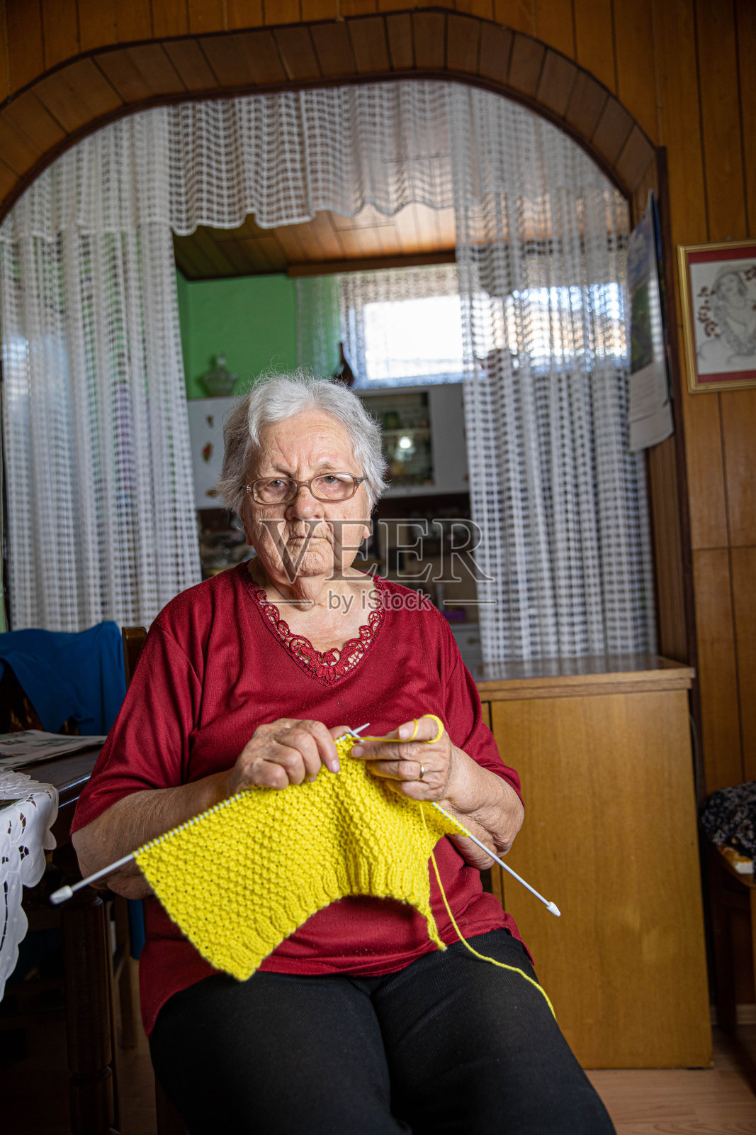 编织工艺:老年妇女制作黄色纺织品照片摄影图片