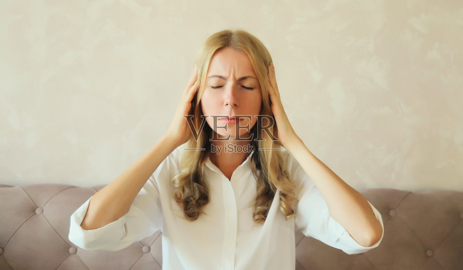 疲惫不堪的女人遭受头痛，压力，疲劳，太阳穴疼痛，偏头痛，大声的噪音照片摄影图片