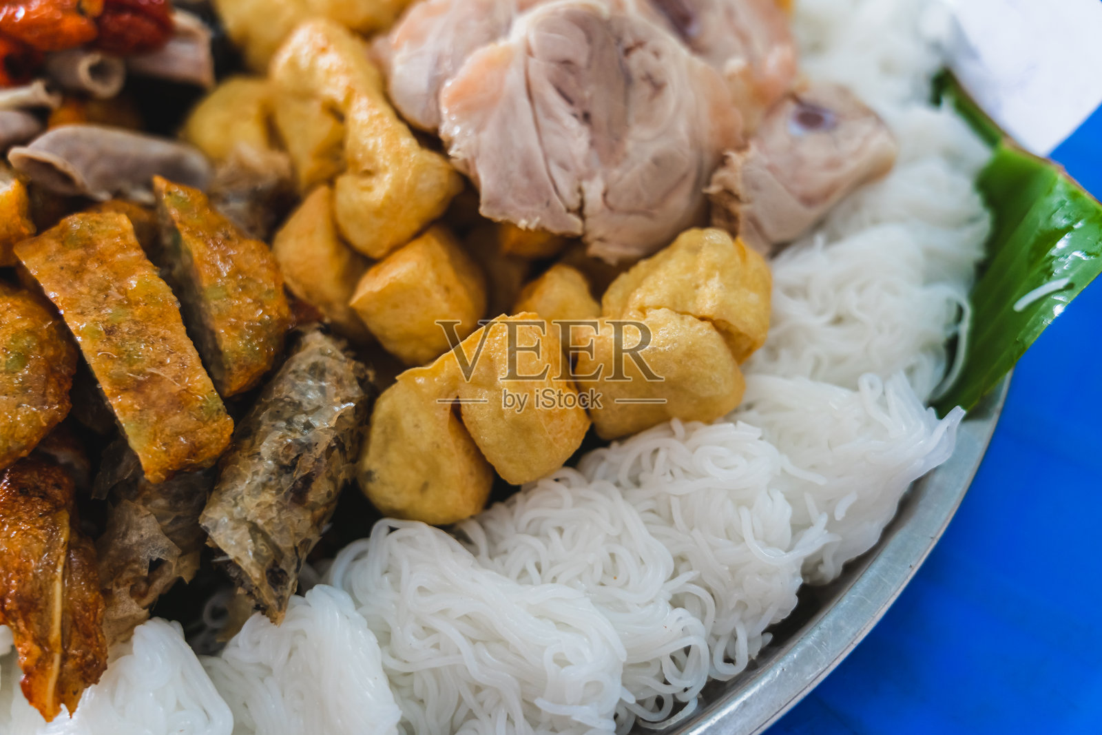 美味的越南菜Bun Dau Mam Tom是一种受欢迎的街头小吃，由米粉、煮肉、炸豆腐、虾酱、绿色蔬菜、黄瓜和辣椒、酸橙等香料制成照片摄影图片