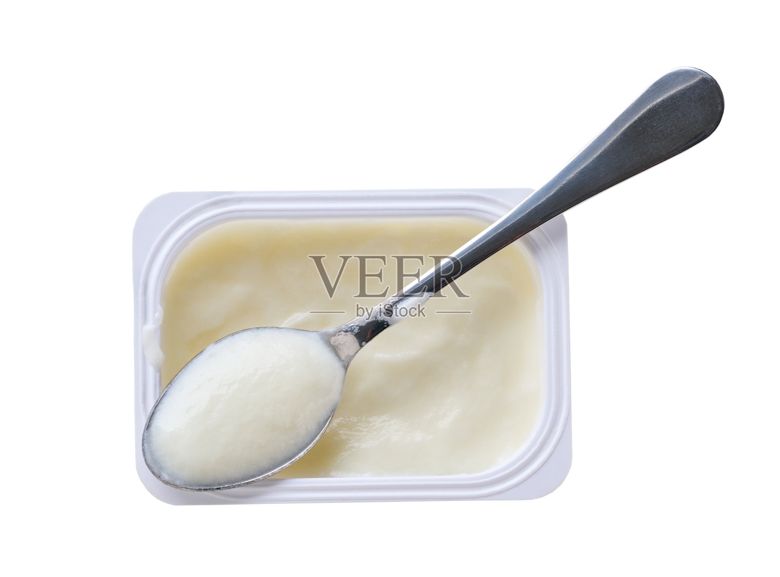 益生菌酸奶装在白色塑料杯里，用勺子隔离在白色背景上。前视图。照片摄影图片