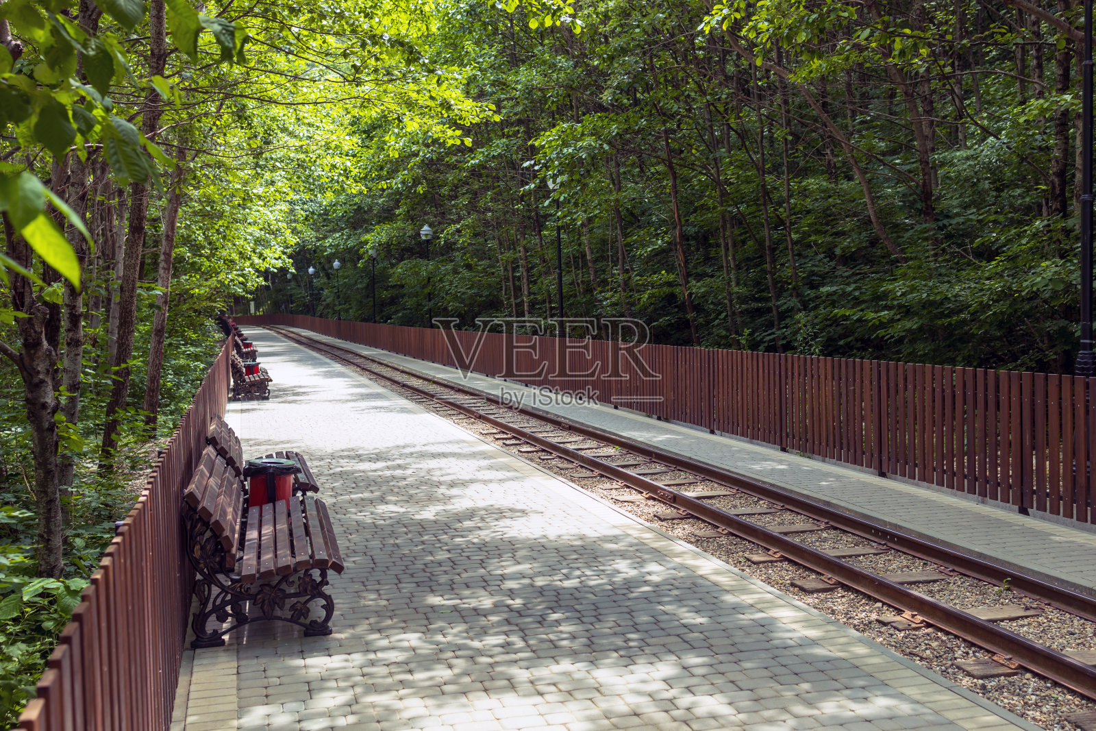 通往峡谷的铁路。关岛峡谷内的窄轨铁路，配有美丽的入口和休息的长凳。照片摄影图片