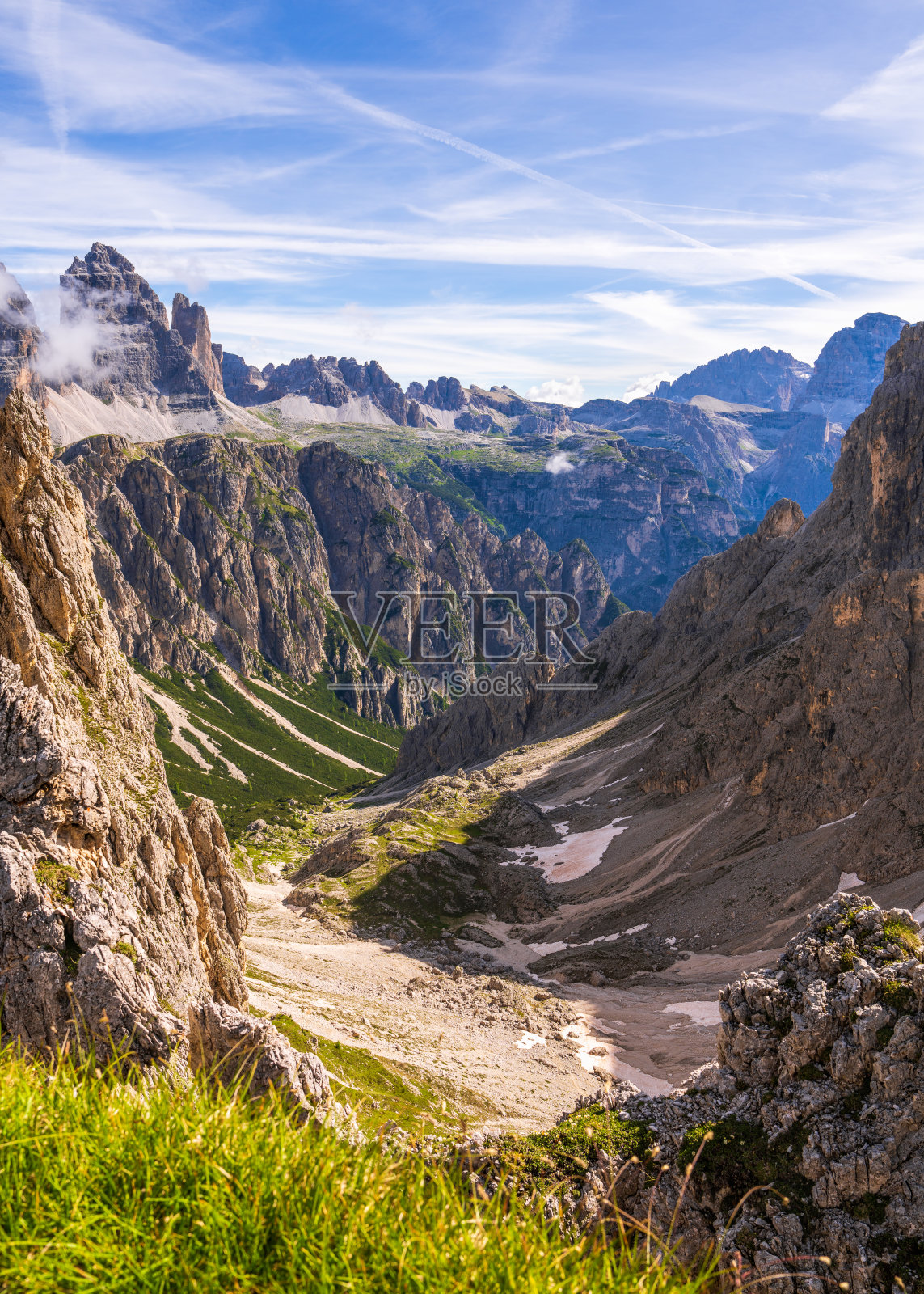 云中隐藏着白云石山峰的景观。山上有残余的雪。夏天天晴，天蓝。绿草覆盖了群山。白云石，南蒂罗尔，意大利照片摄影图片