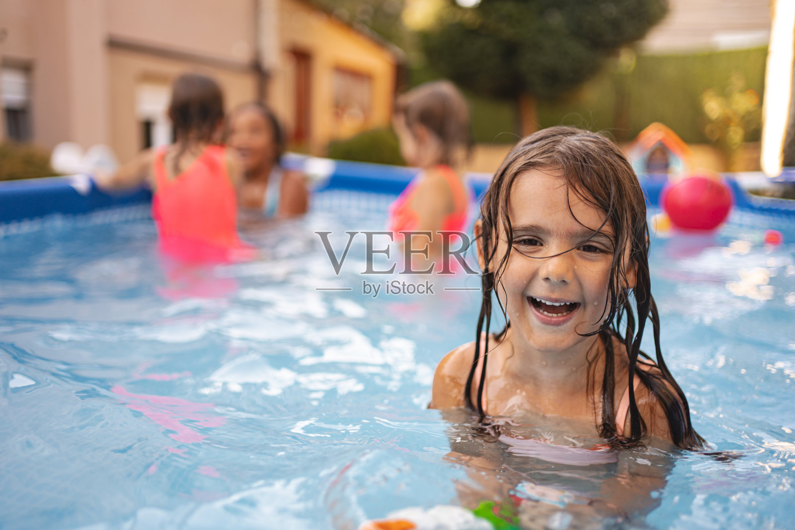 泳池里一个微笑的女孩的肖像照片摄影图片