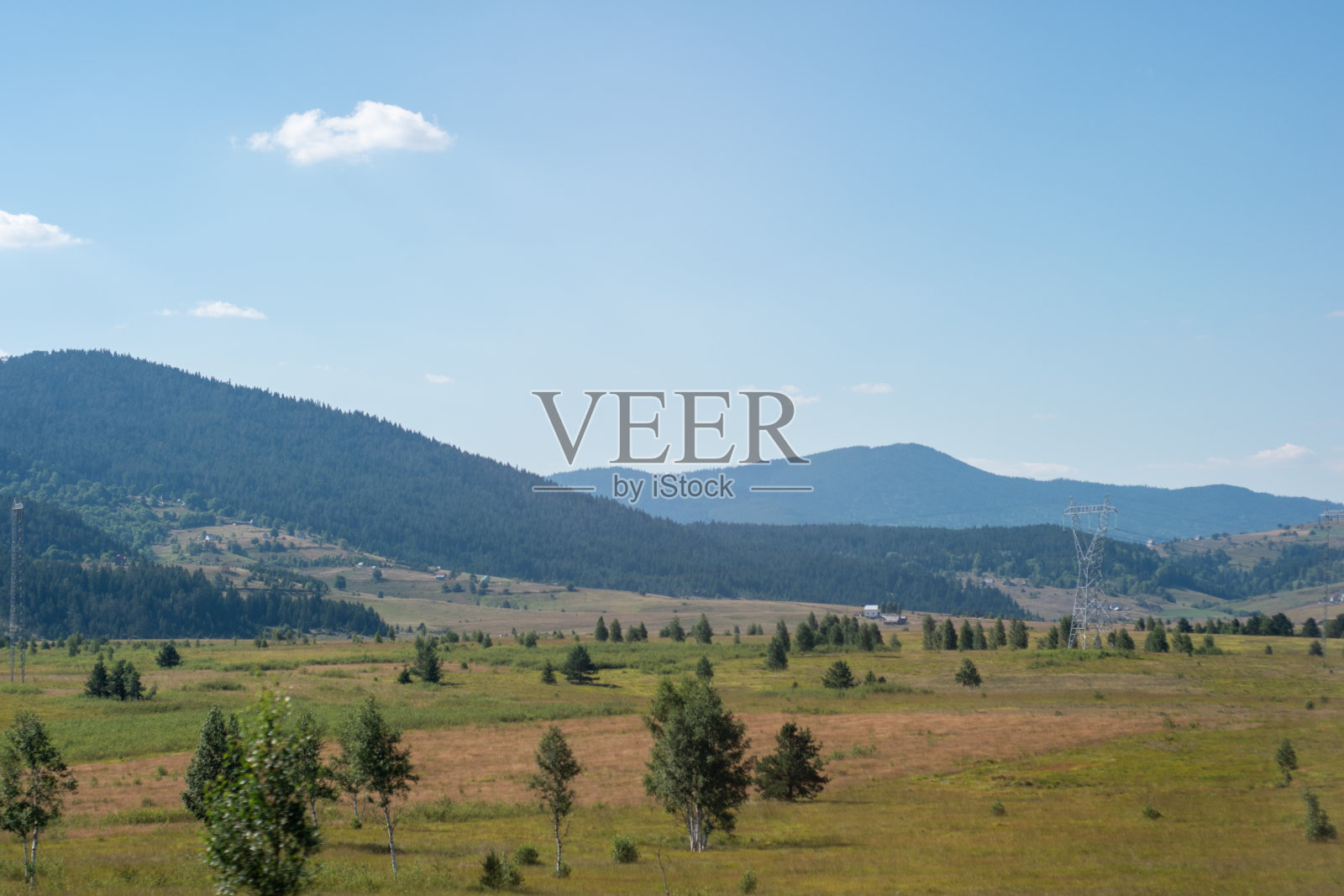 在一个阳光明媚的日子里，山中的绿色田野景观照片摄影图片