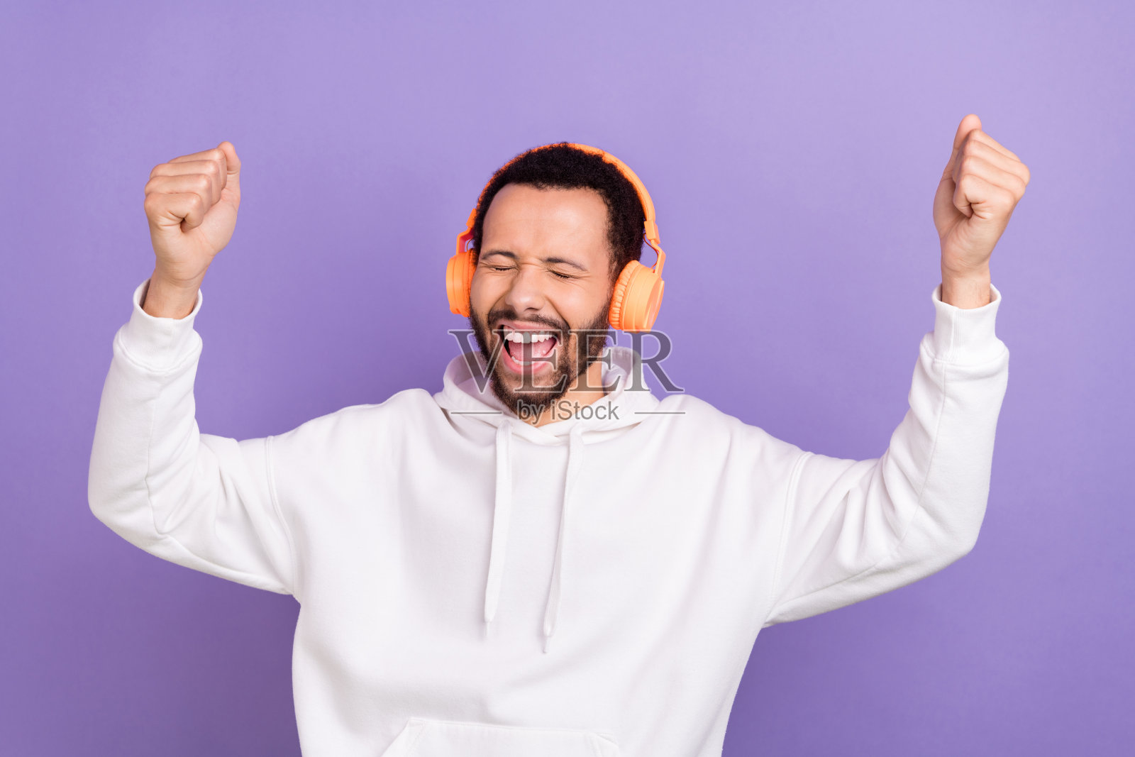 照片积极的人穿着白色连帽衫指导举起手臂听能量音乐的耳机孤立的紫色背景照片摄影图片