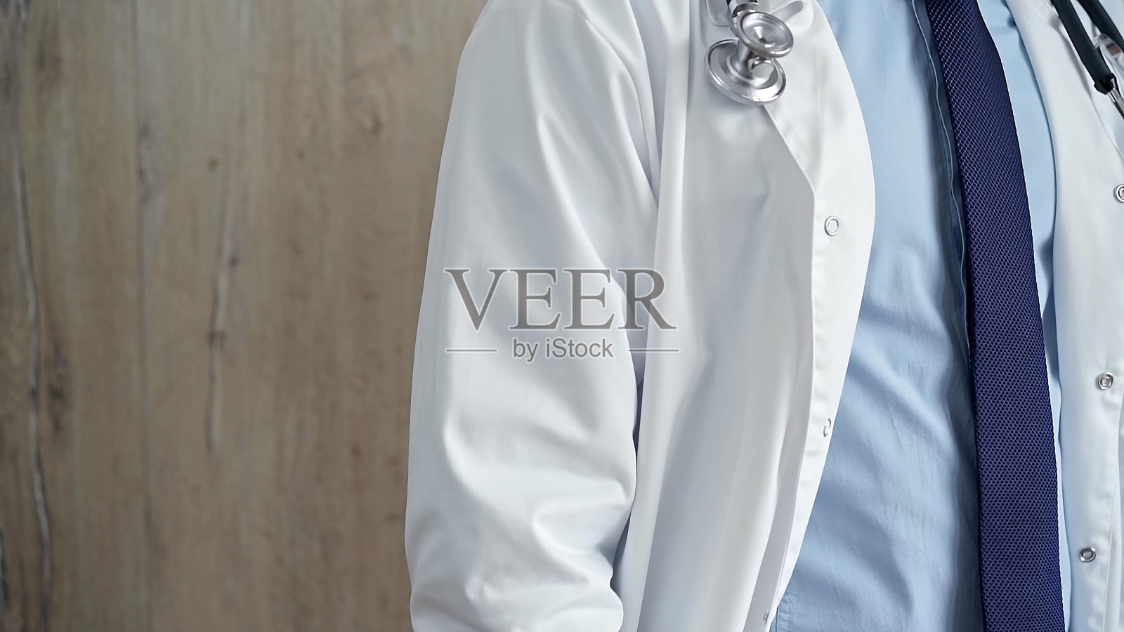 穿着白大褂，带着听诊器的专业医生照片摄影图片