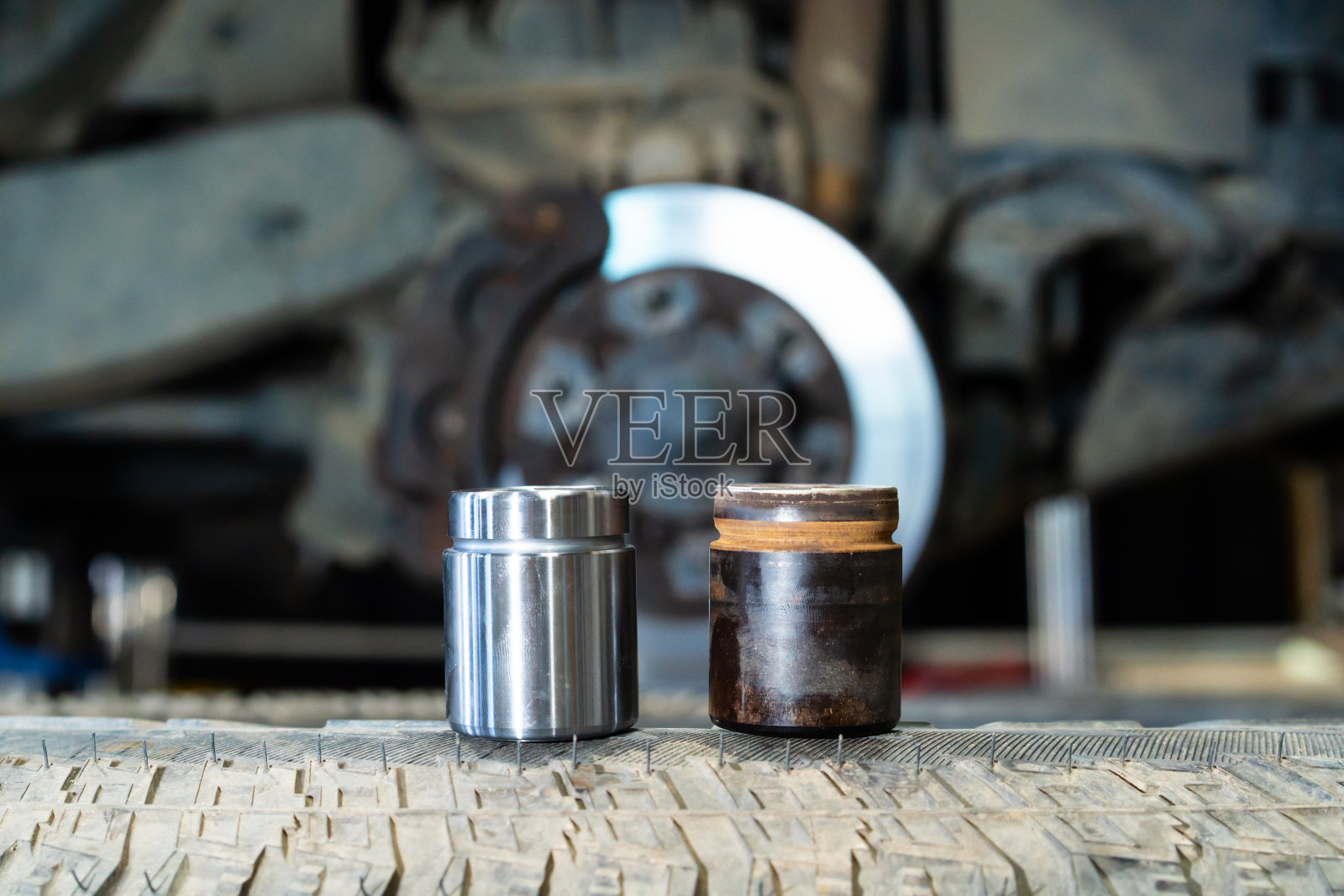 新旧盘式制动卡钳活塞。照片摄影图片