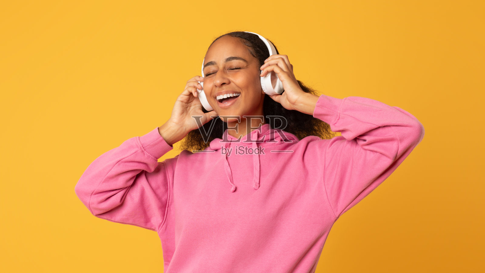 快乐的非洲少女戴着耳机在音乐中放松照片摄影图片