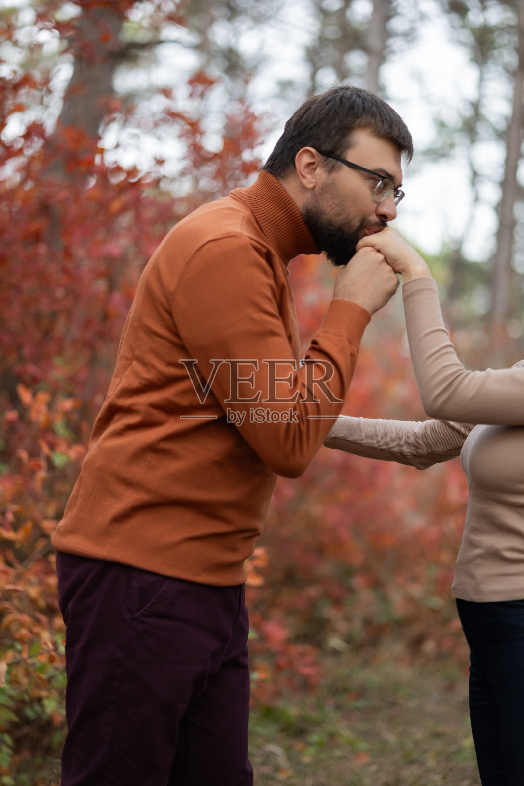 秋天的森林里，男人亲吻女人的手照片摄影图片