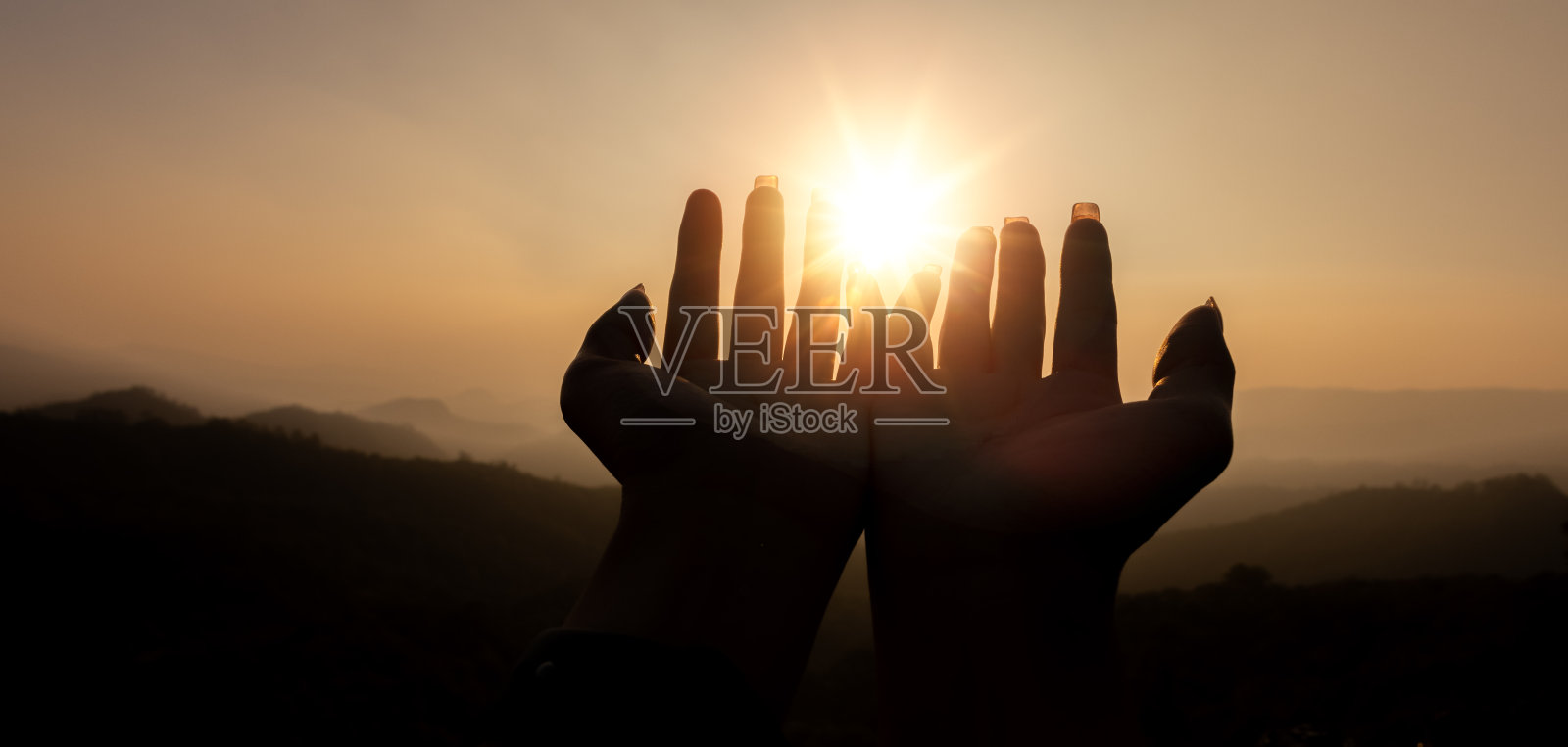 人的剪影妇女的手展示他们的宗教信仰。妇女们手牵手祈祷，通过崇拜耶稣基督来表达他对上帝的宗教信仰。在祷告中转向上帝照片摄影图片