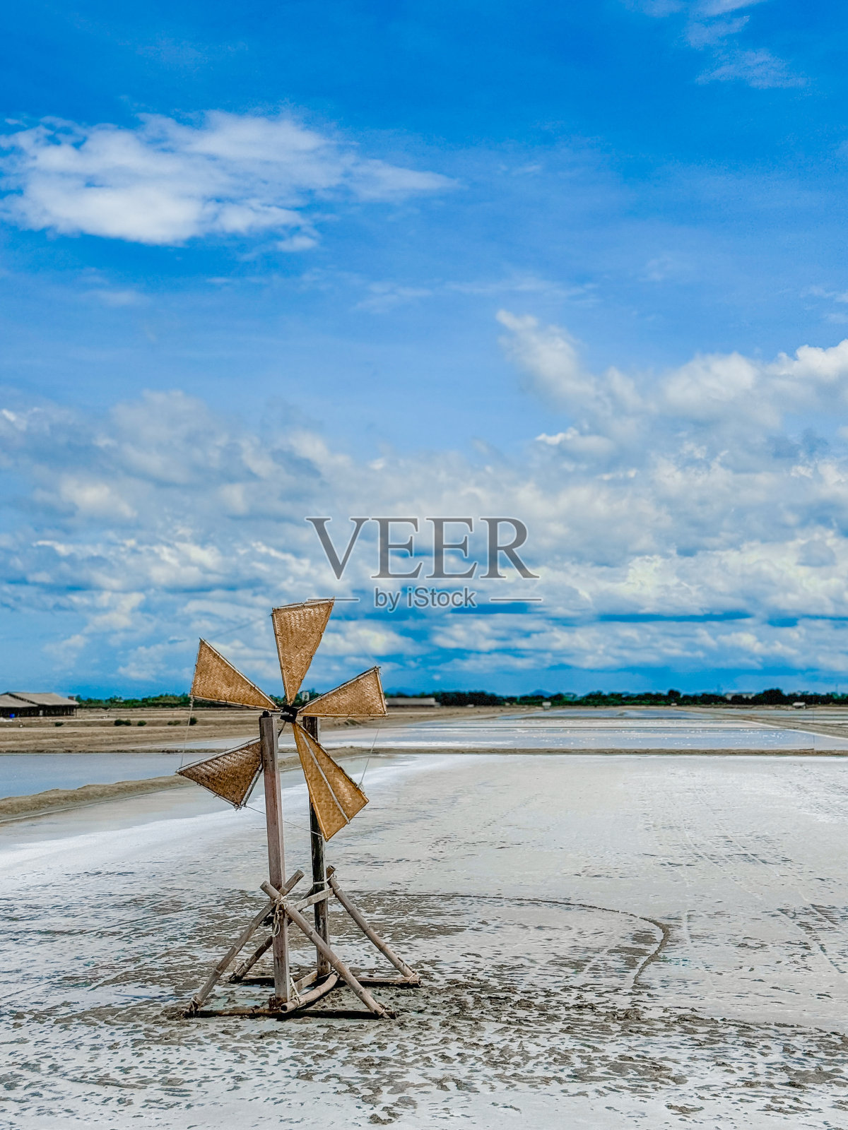 蓝天下盐田里的木制风车照片摄影图片