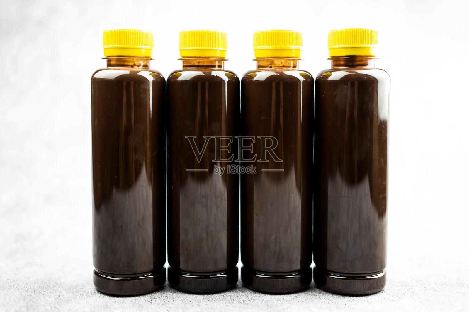 透明的巧克力牛奶或可可牛奶装在黄色盖子的透明瓶子里。照片摄影图片