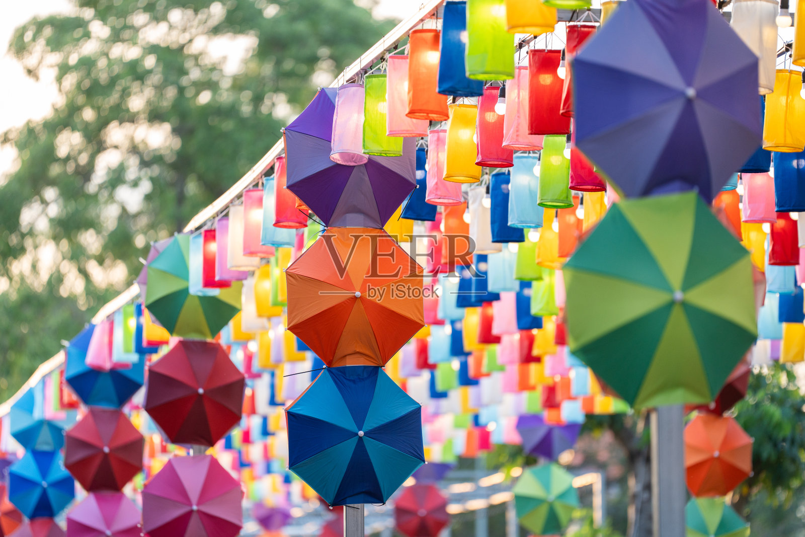 五颜六色的遮阳伞和一排排挂着水晶的灯笼，营造出一种迷人的散景光，在整个花园中翩翩起舞，营造出一种宁静而美丽的景色。照片摄影图片