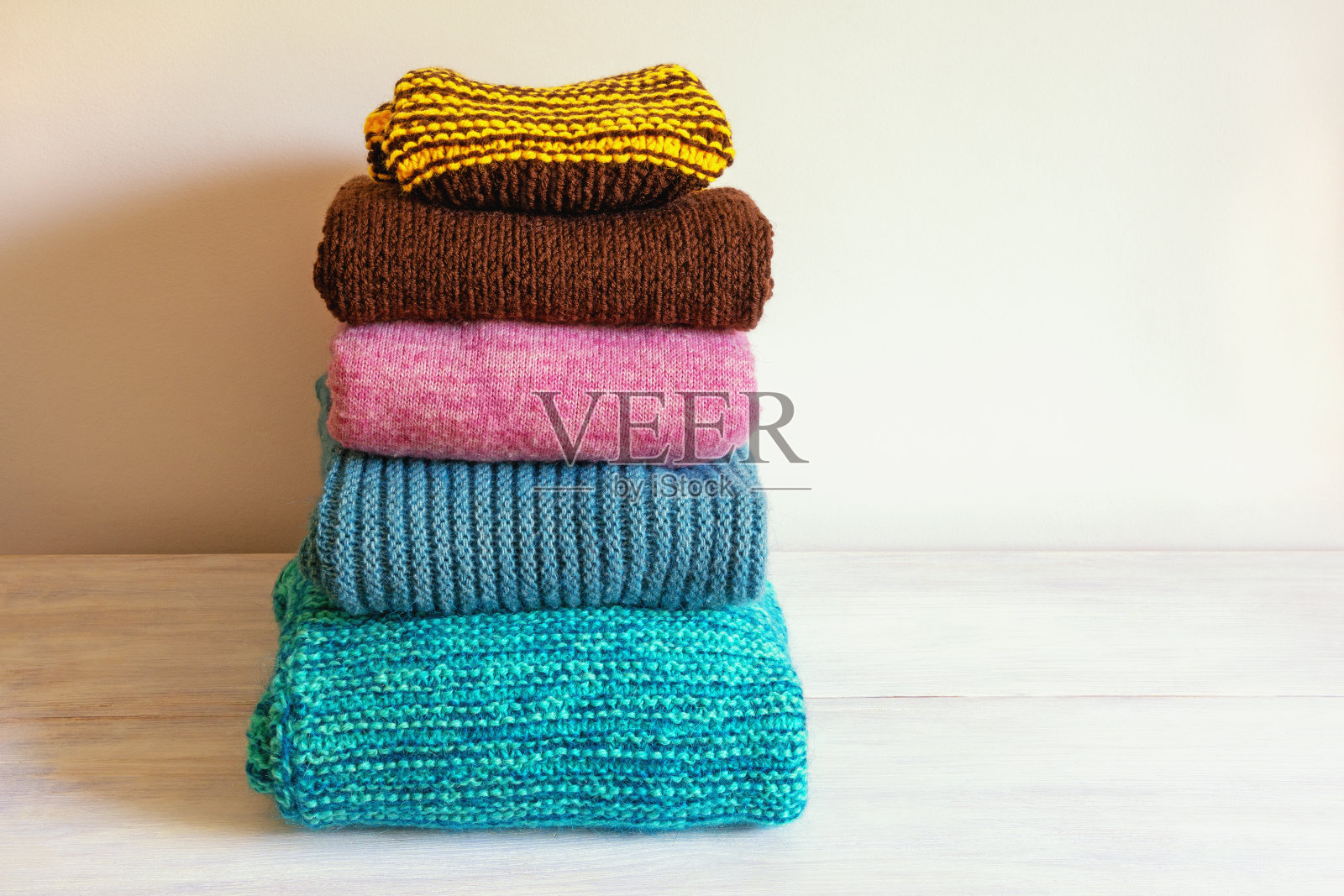 一堆温暖的针织毛衣放在质朴的桌子上。本空间照片摄影图片