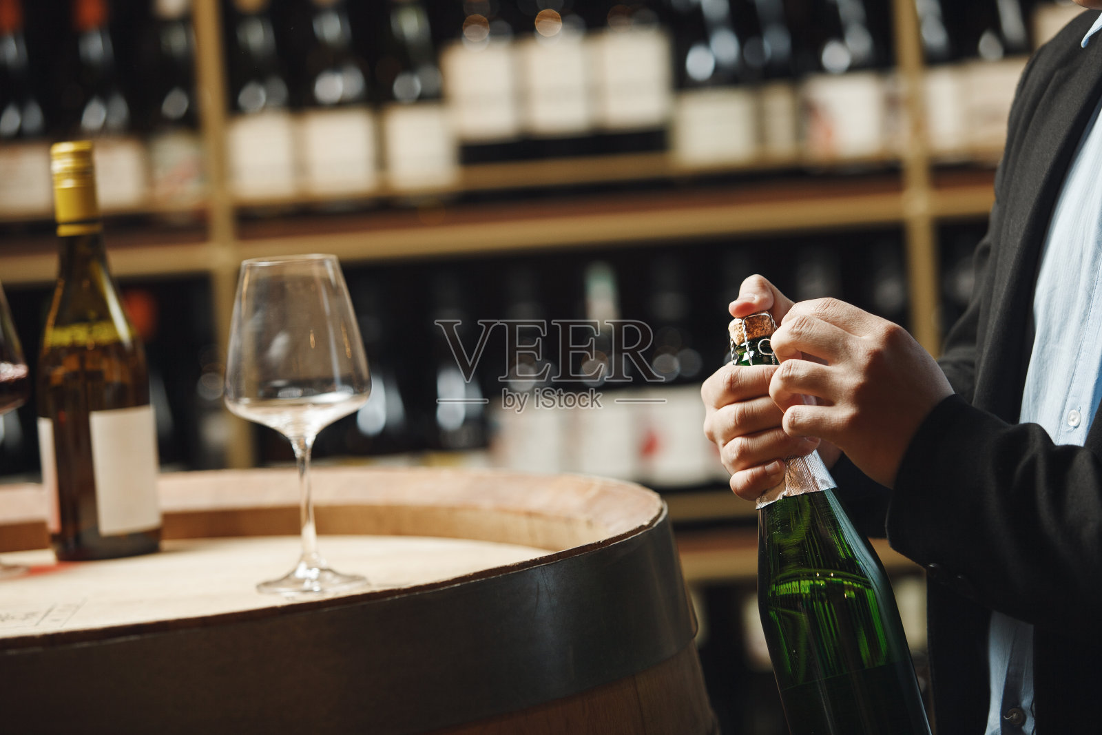 葡萄酒专家小心地打开酒窖中的起泡酒瓶照片摄影图片