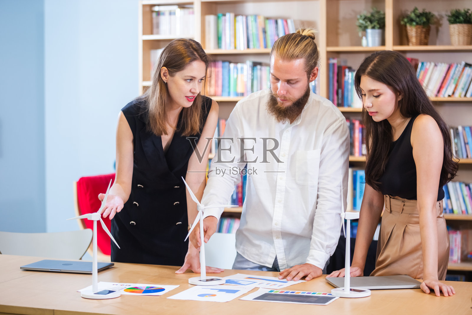 一群商务人士开会集思广益项目创新能源生态可再生的风力涡轮机技术。商人谈论替代环境。照片摄影图片