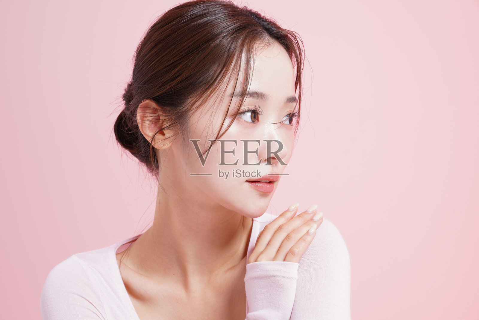 一个年轻女子在粉红色背景下拍摄的漂亮肖像照片摄影图片