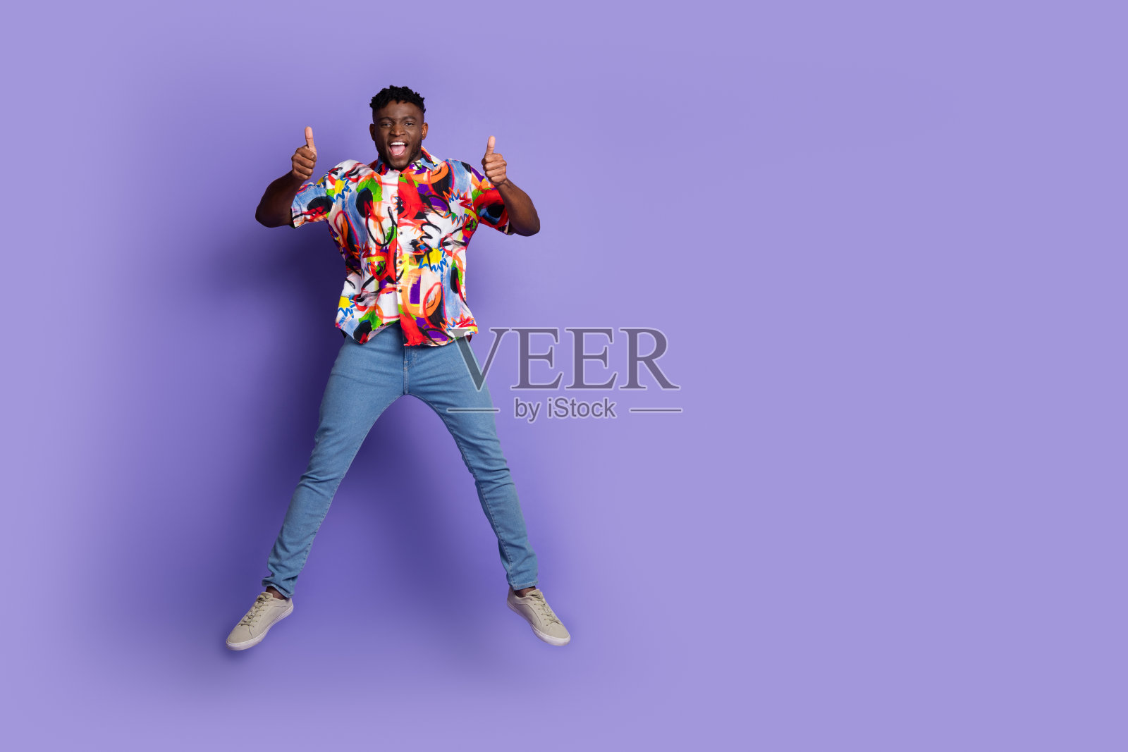 漂亮的年轻人的全身肖像跳跃拇指向上空白空间孤立的紫色背景照片摄影图片