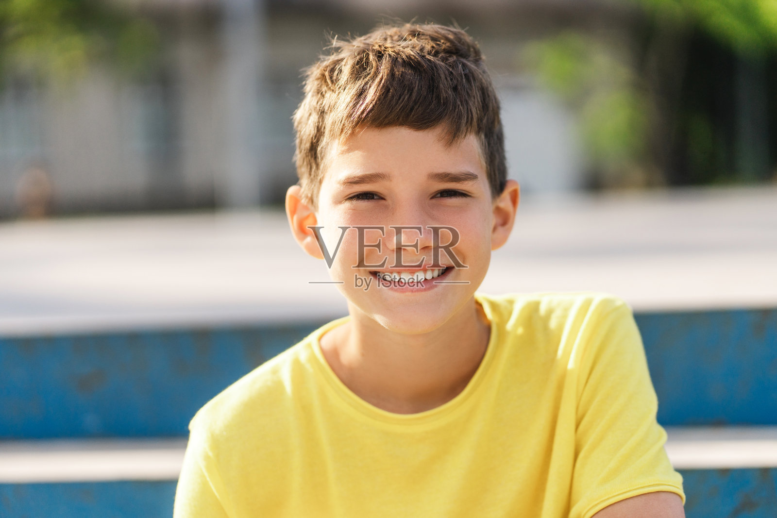 肖像微笑的男孩少年穿着黄色t恤看着相机坐着照片摄影图片