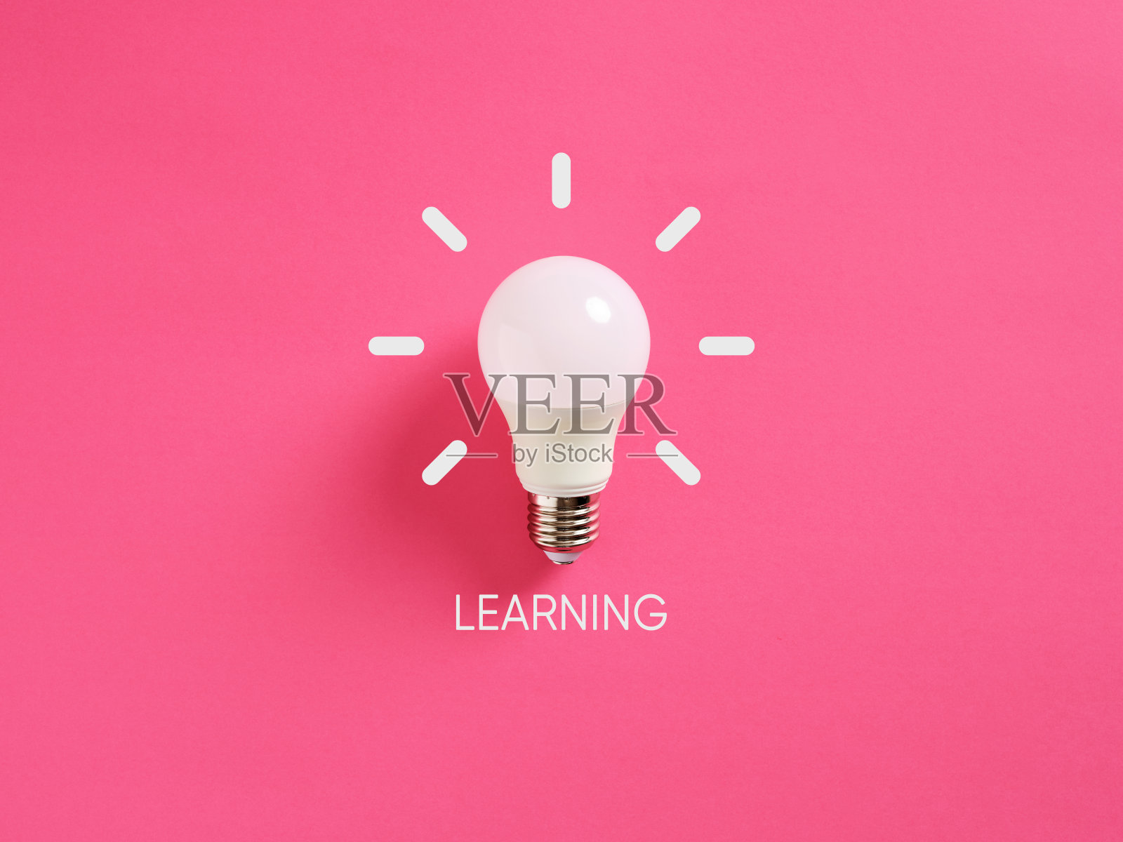 白色灯泡在粉红色的背景上闪烁，学习概念照片摄影图片