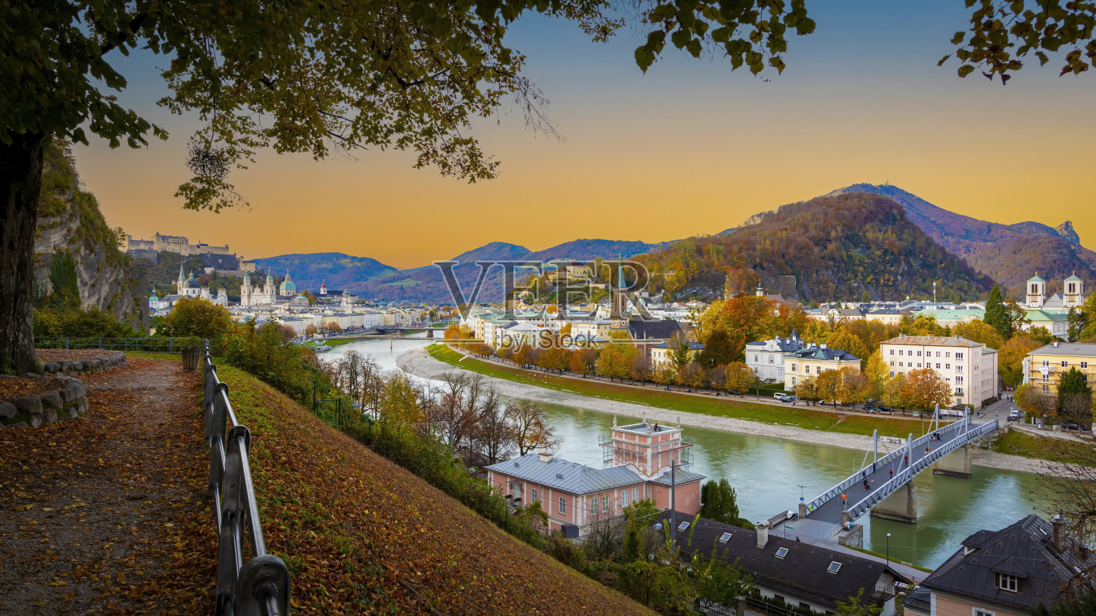 秋天的萨尔茨堡是一座历史悠久的城市，在美丽的日落天空中，萨尔茨堡河和色彩缤纷的秋天景色，奥地利萨尔茨堡照片摄影图片
