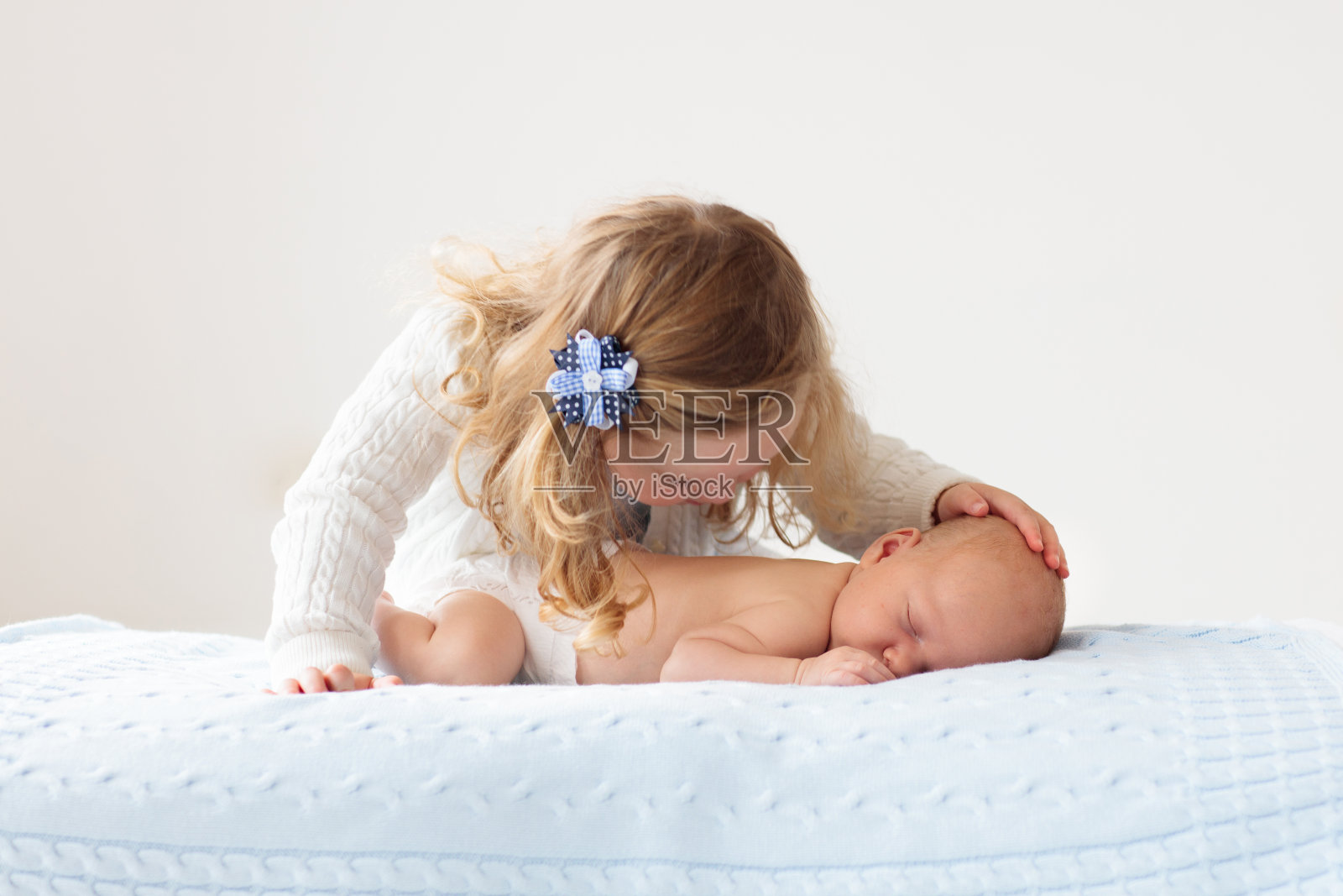 孩子在摇篮里看着刚出生的婴儿。照片摄影图片