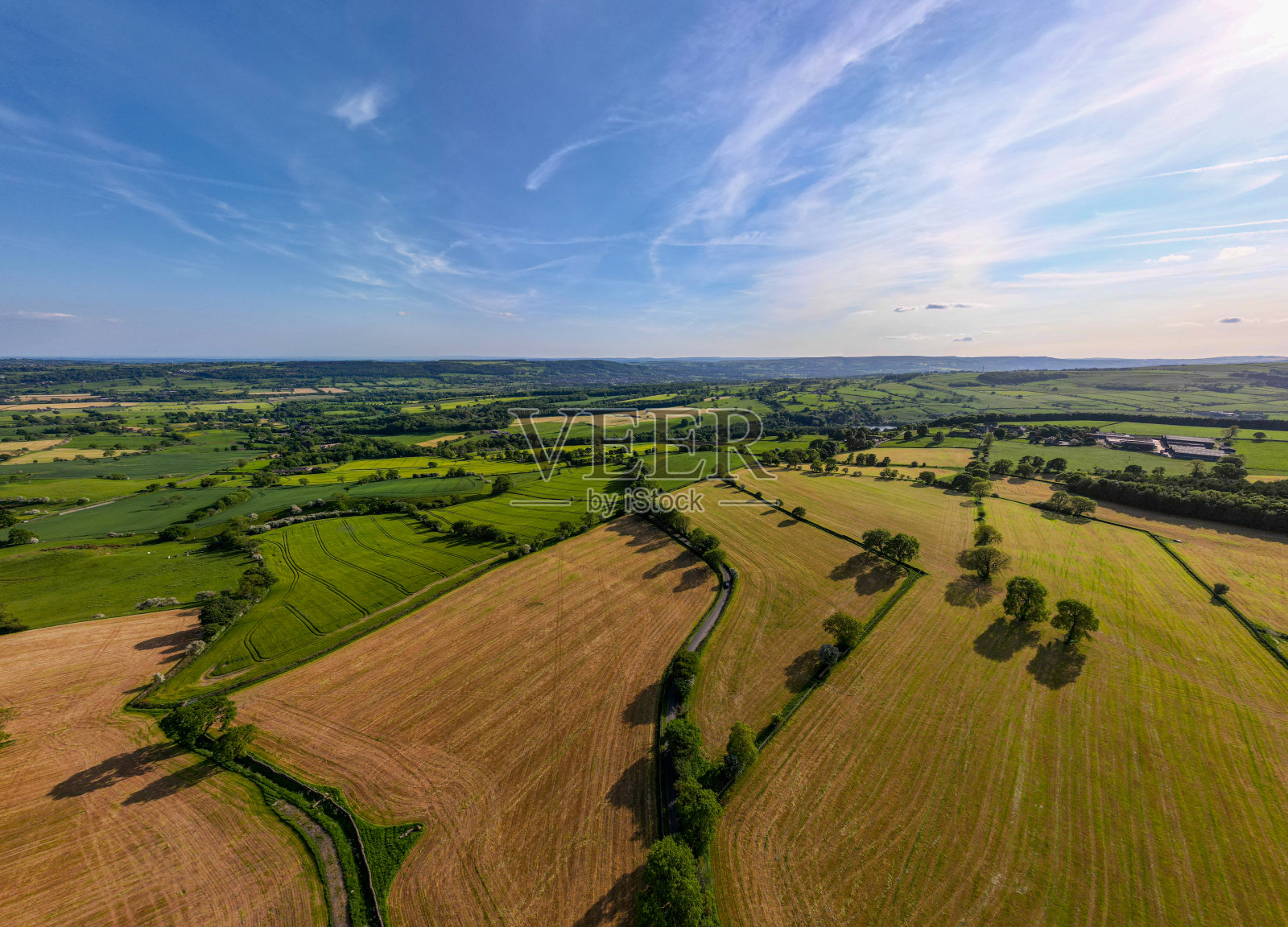 鸟瞰蓝天下郁郁葱葱的乡村，田野错落有致照片摄影图片