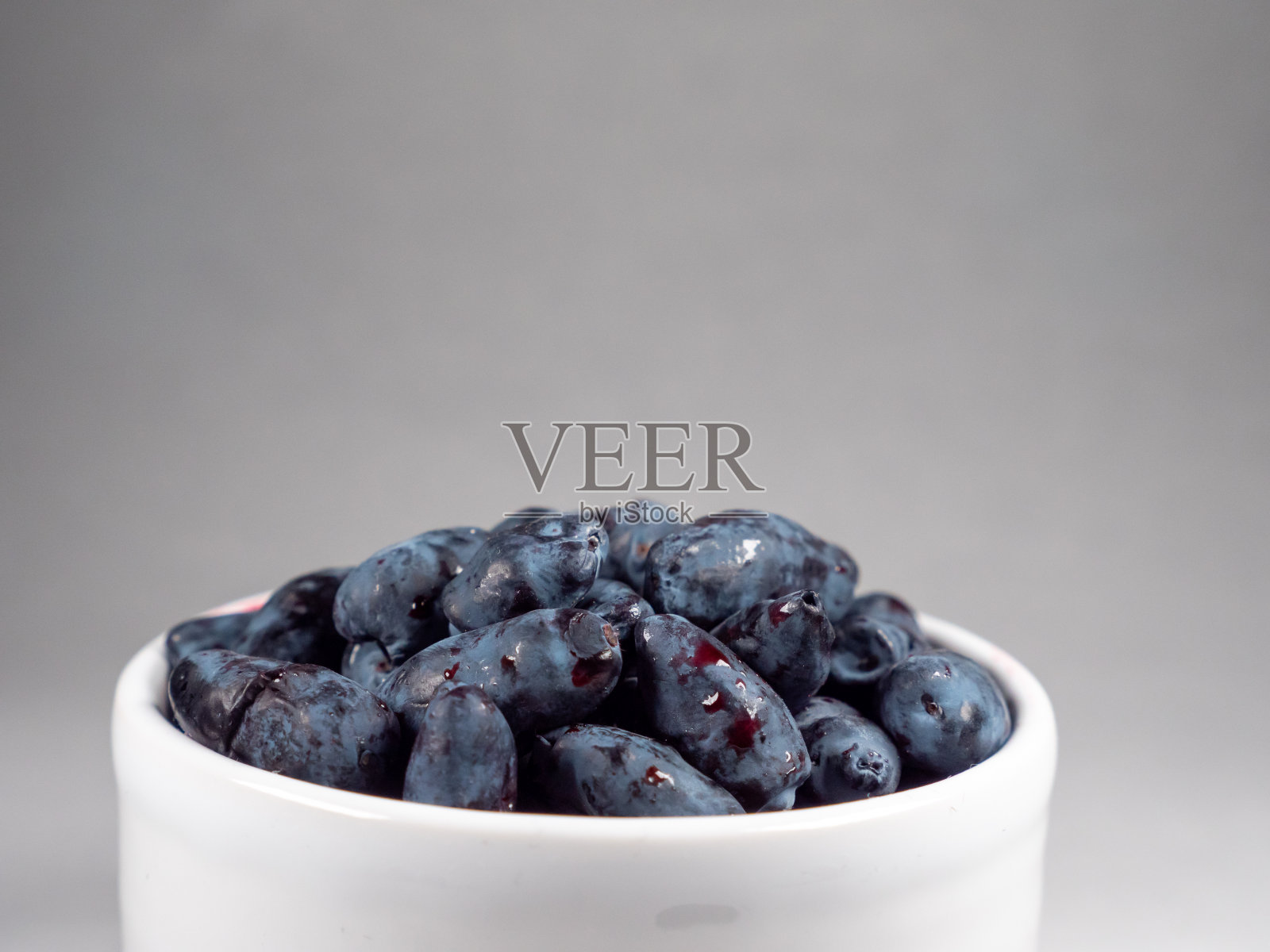 白色杯子里的新鲜蜂蜜浆果照片摄影图片