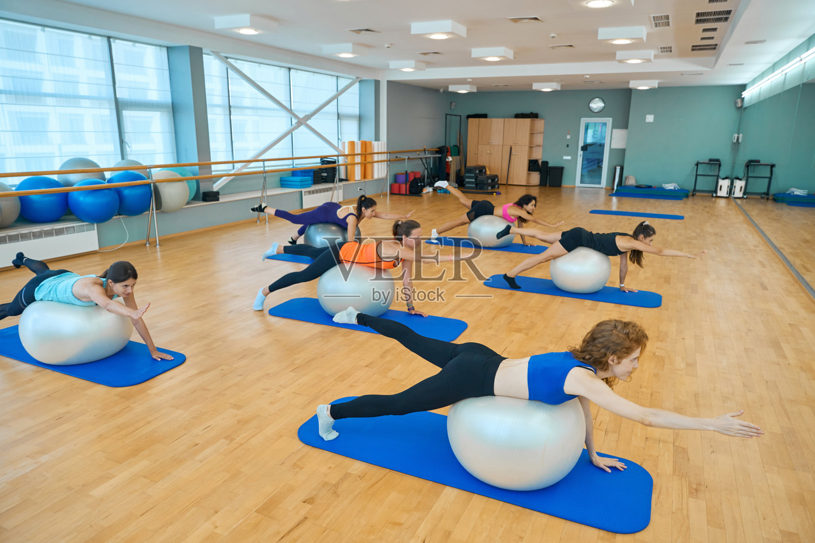 年轻女子在大球上健身照片摄影图片