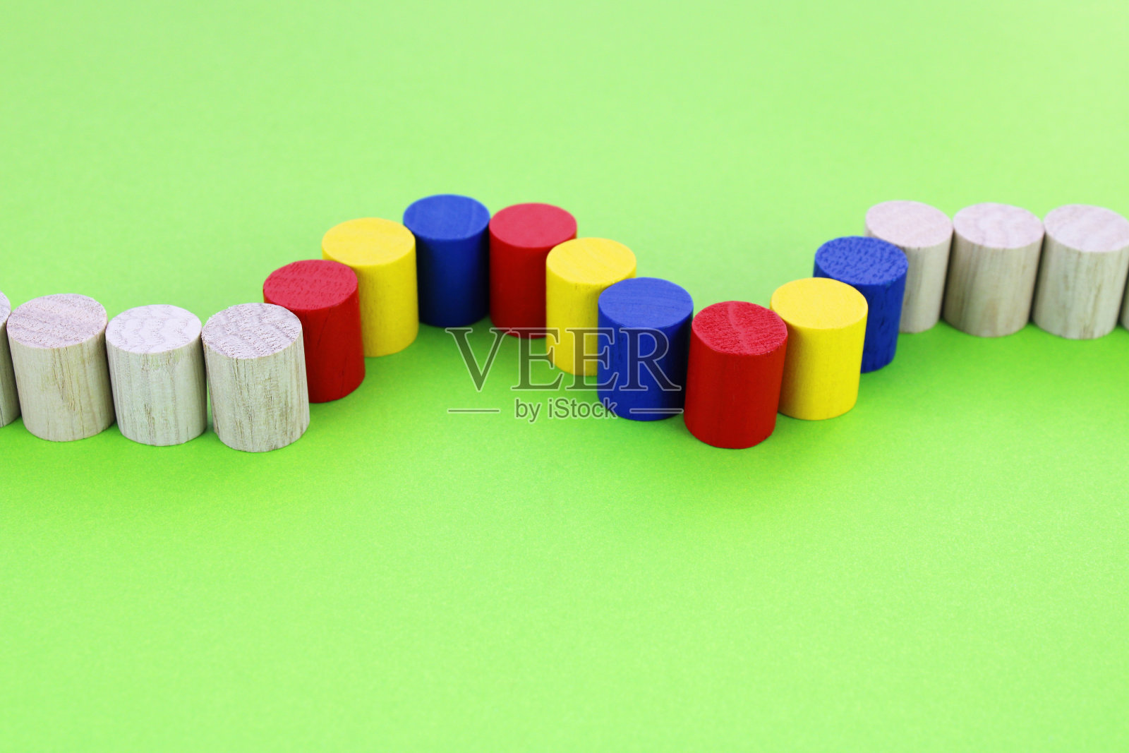 一排木柱，其中有几个颜色不同，形成两条曲线照片摄影图片