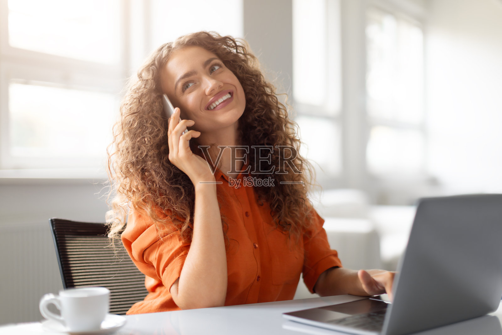 一个女人在用笔记本电脑打电话照片摄影图片