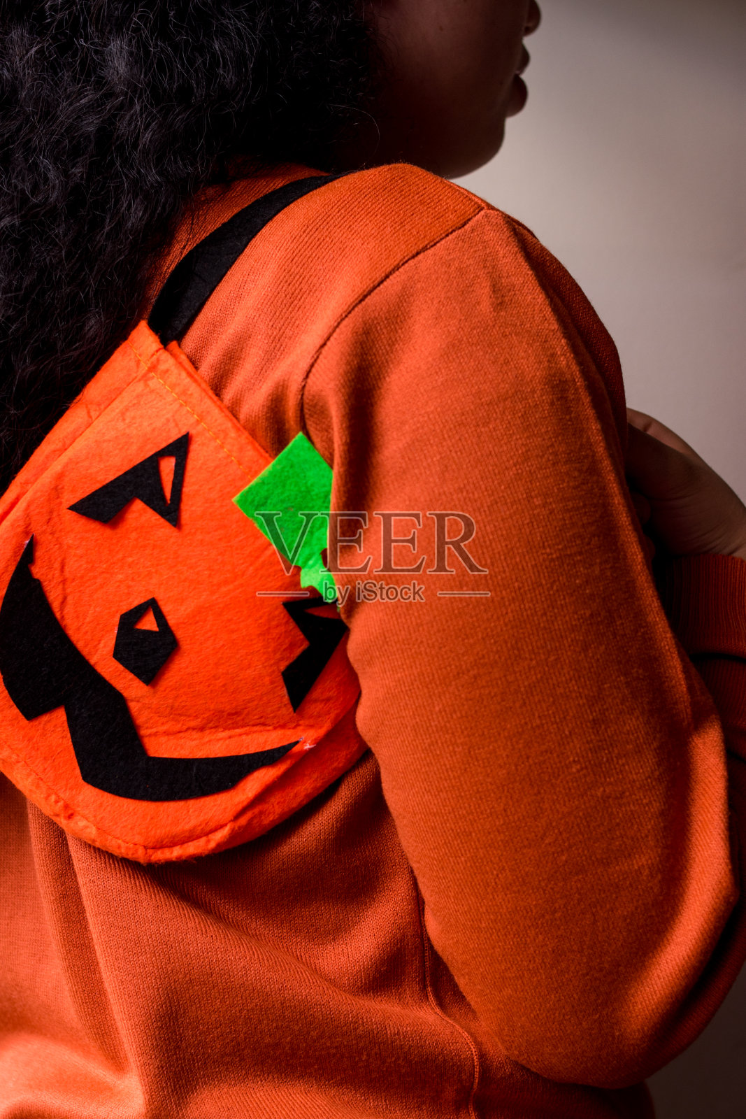 拿着橙色的万圣节南瓜袋照片摄影图片