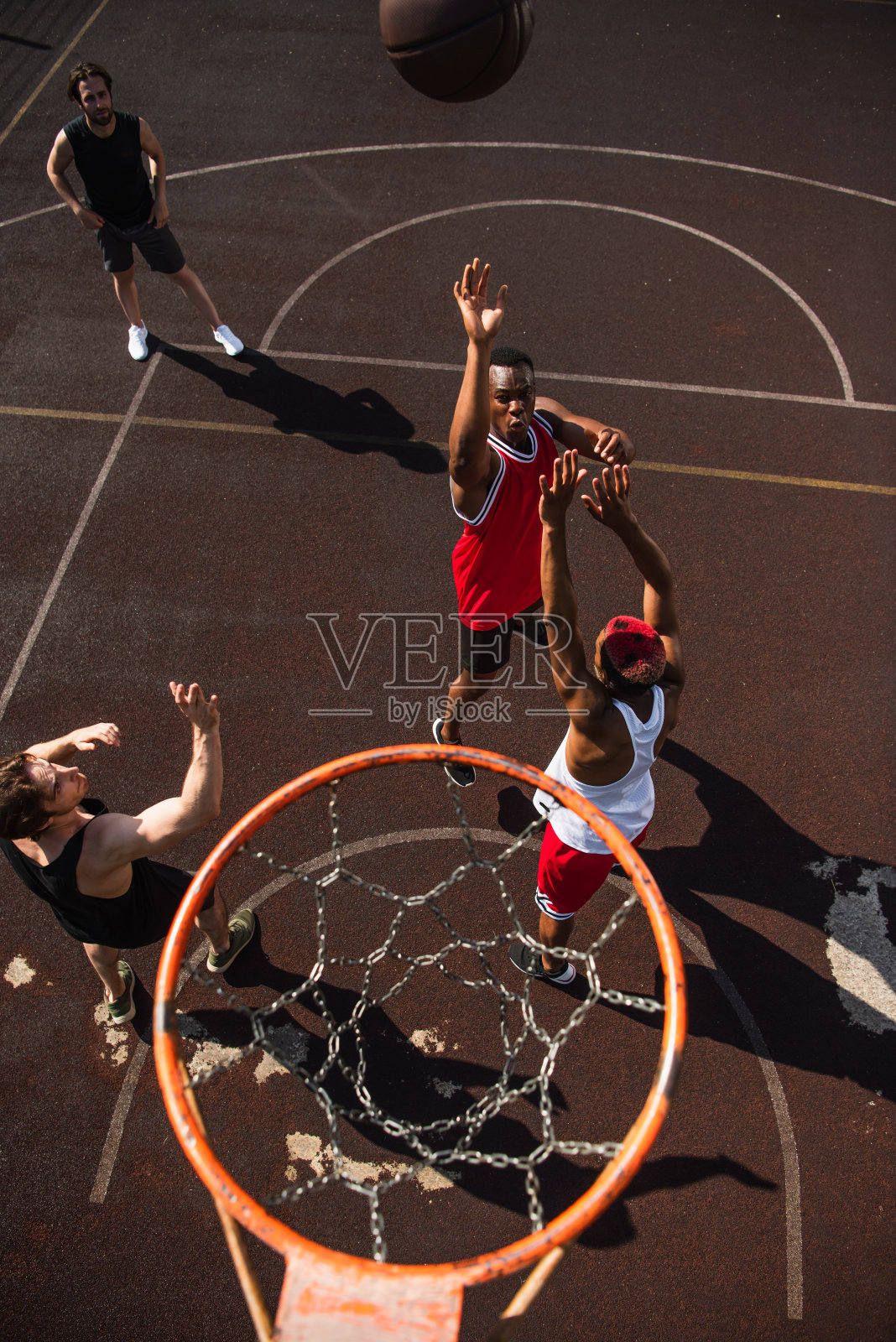 朋友们在日落时分与不同的球员一起享受一场充满活力的户外篮球比赛照片摄影图片