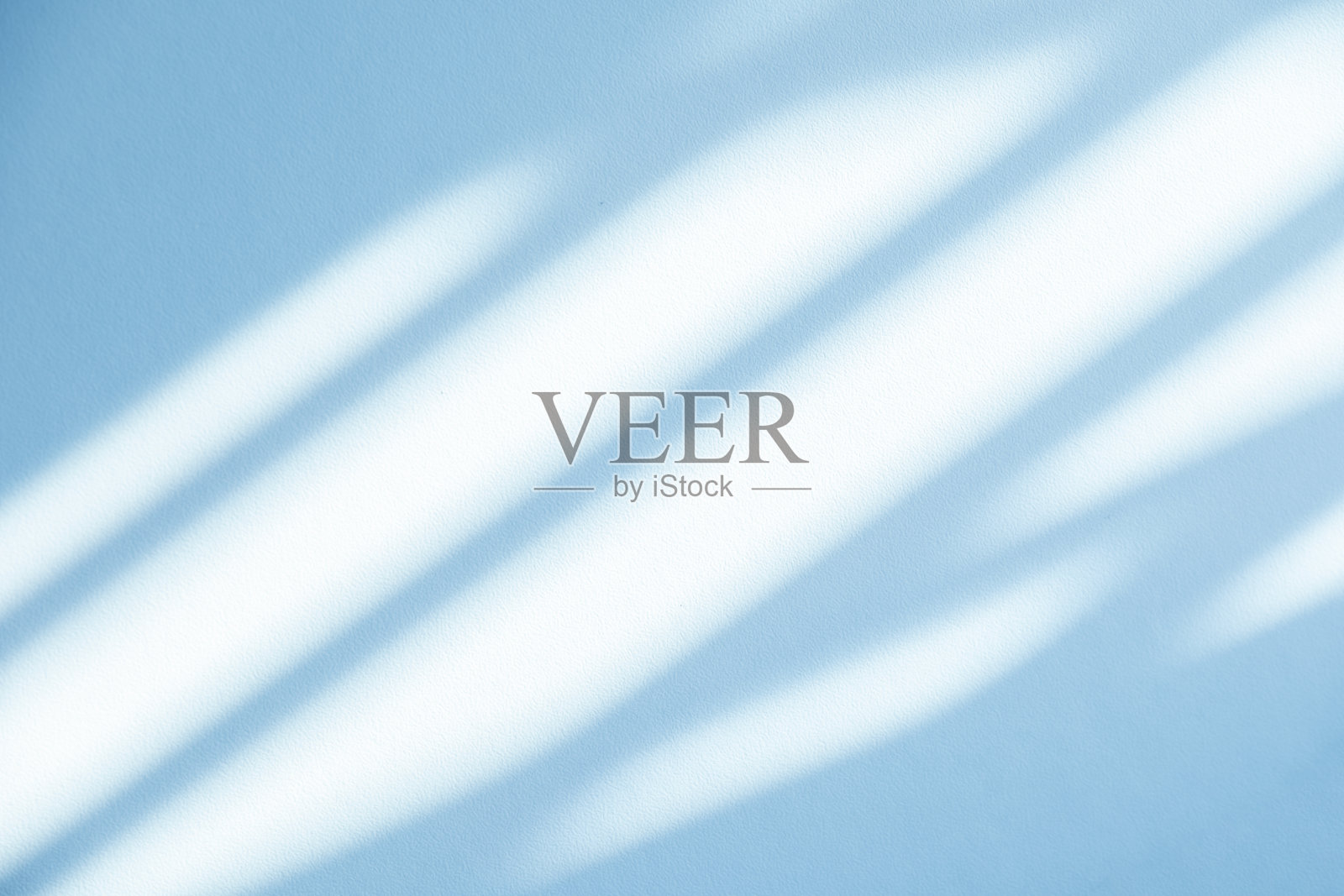 工作室风格的背景墙装饰呈现采用白色和蓝色调。阴影从附近的窗户投射出来，创造了一个装饰性的概念照片摄影图片