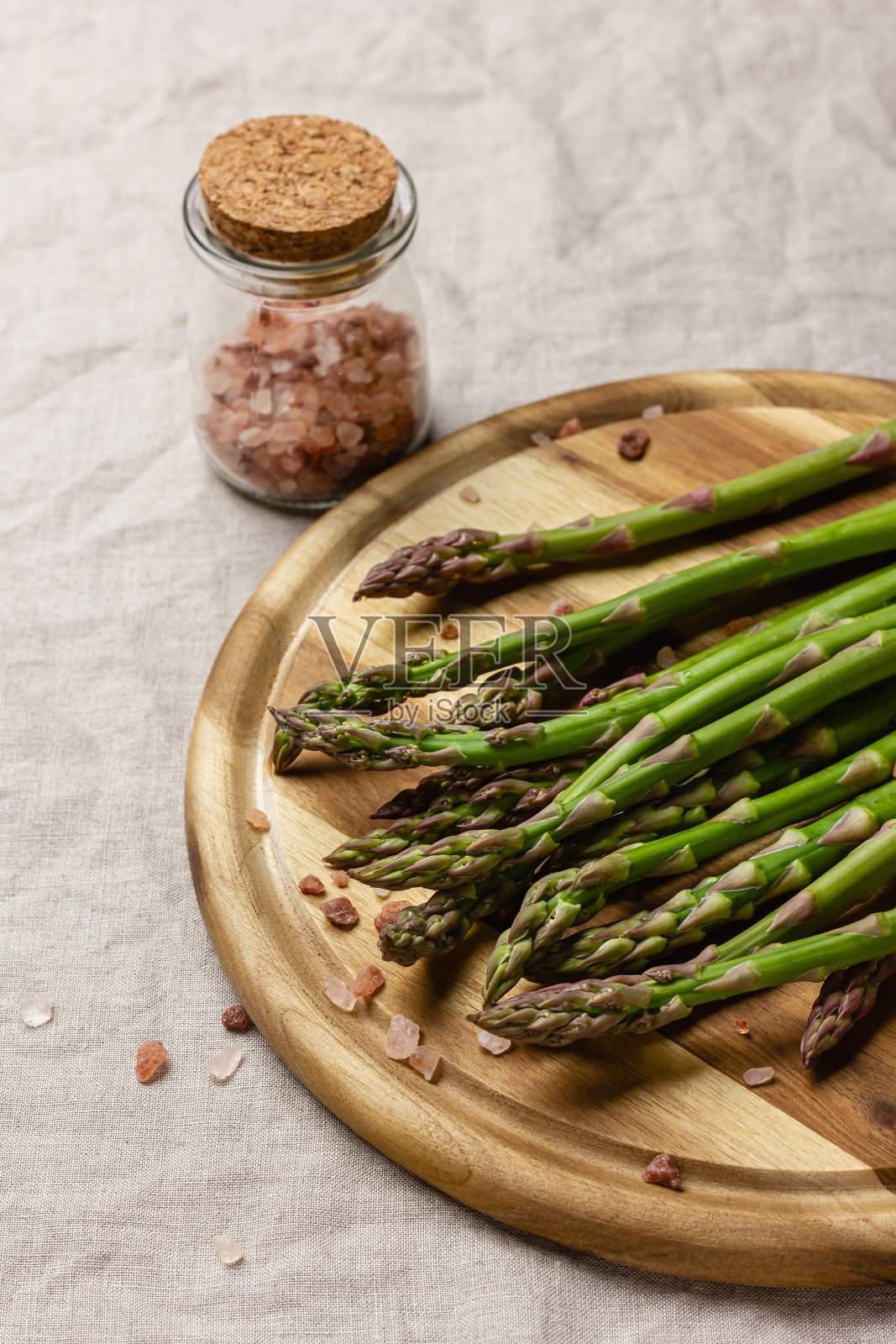 木制砧板上的粉盐绿色芦笋照片摄影图片